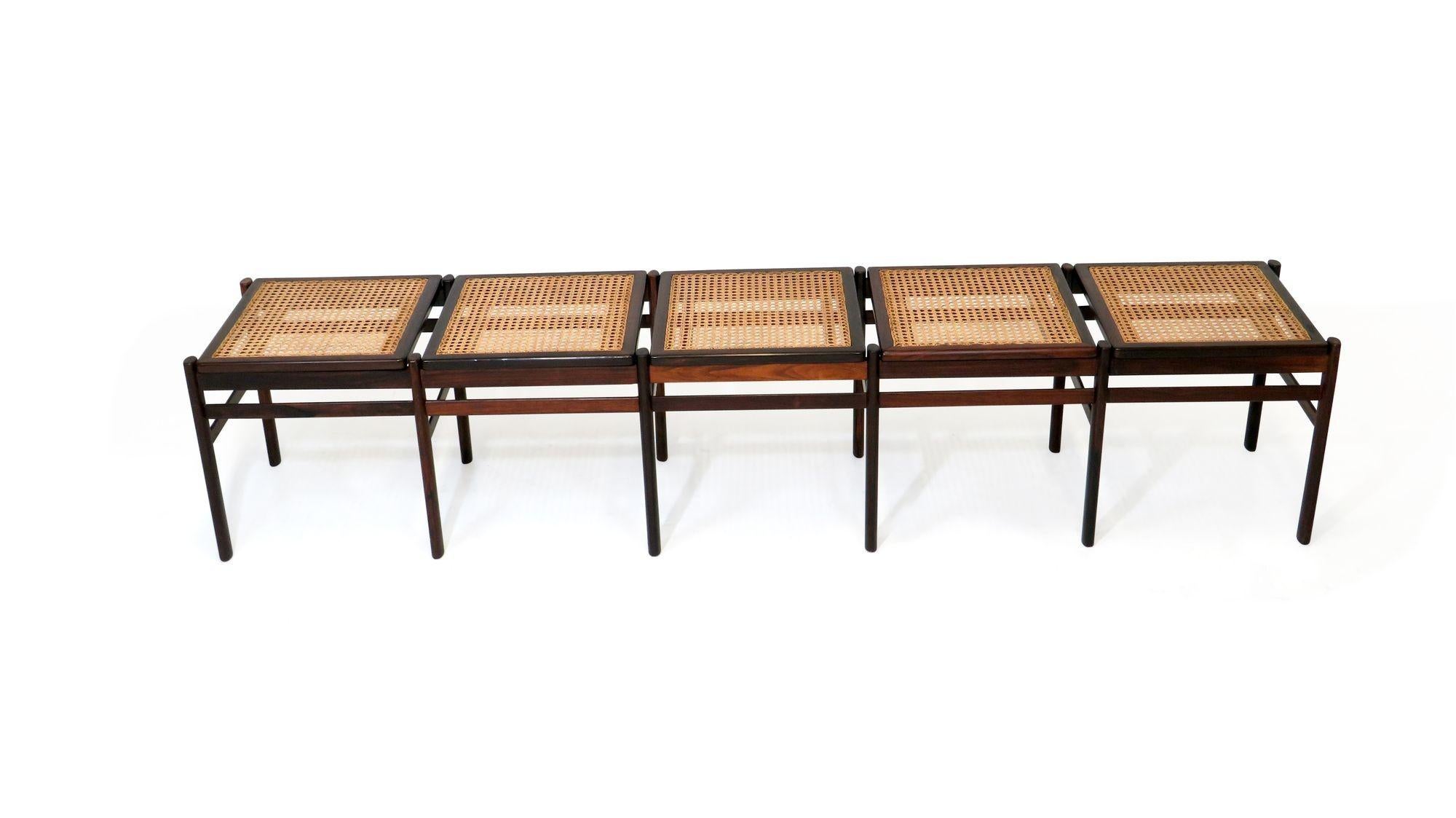 Bench crafted of dark figured solid Brazilian rosewood and hand woven cane in manner of Joaquim Tenreiro.

Bench is in excellent condition with minor signs of age and use.

Measurements 
W 84.25'' x D 16.75'' x H 17''.