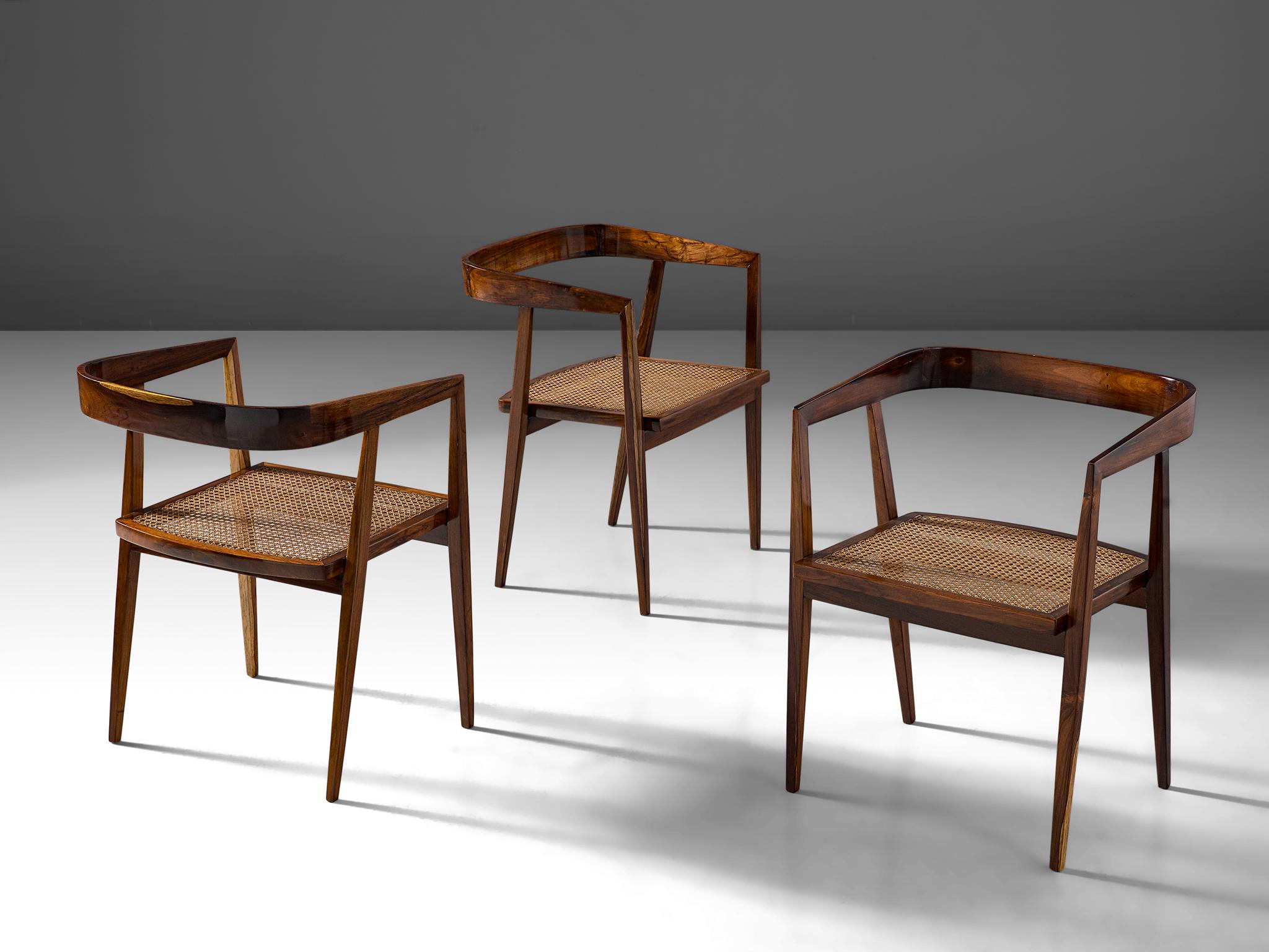 Joaquim Tenreiro, set of 3 dining chairs, rosewood, cane, Brazil, circa 1960.

This exceptional set is designed by the Brazilian master designer and woodworker Joaquim Tenreiro. The chairs main feature is their wide, luxurious cane seat and light,