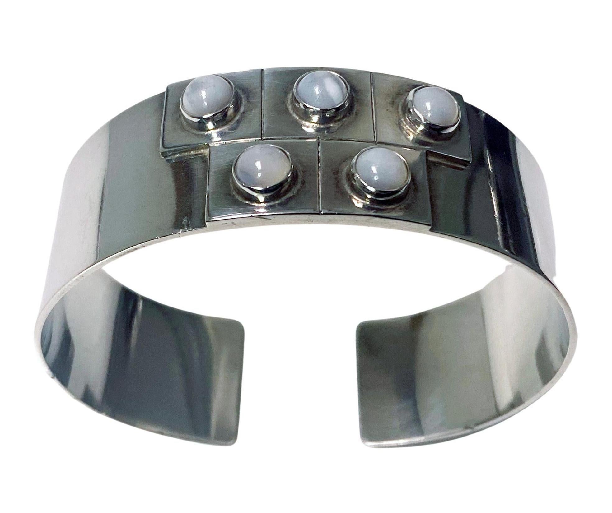 Joaquin Tinta Sterling Silver and white bead cuff bracelet bangle. Polished background with raised squares design each inset with bezel set pearl like bead. Stamped Ecuador Sterling Tinta. Width 7/8 inches. Weight: 47 grams. Will fit up to 7.5-inch