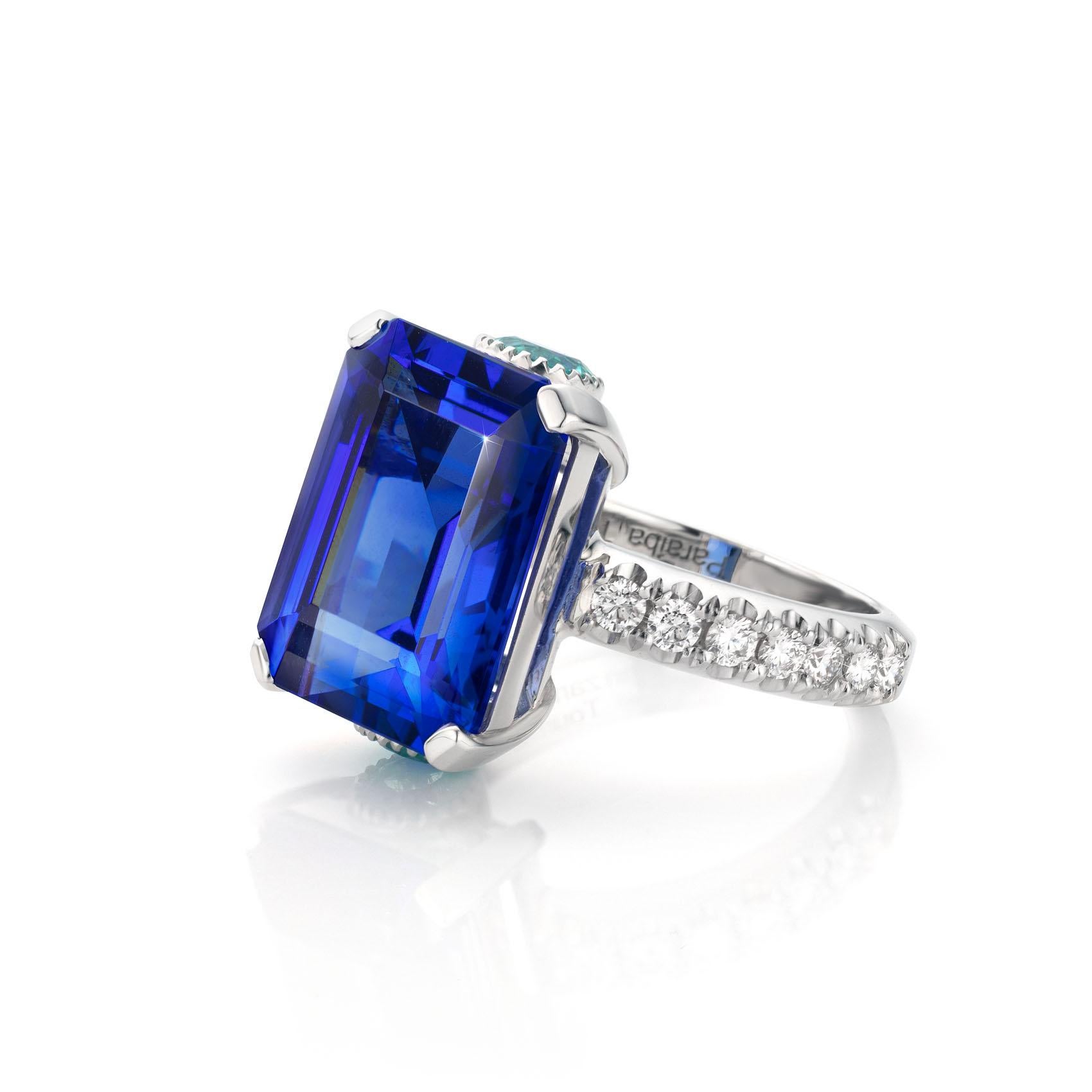18 Karat White gold Cocktail Ring featuring a 12.4 Carat Tanzanite stone.

Emerald cut measuring 15.4 x 12.1 mm.
The Tanzanite Ring is set with 0.76 Carat Paraíba Tourmaline stones and Collection Grade Diamonds weighing 0.57 ct.

The vivid violetish