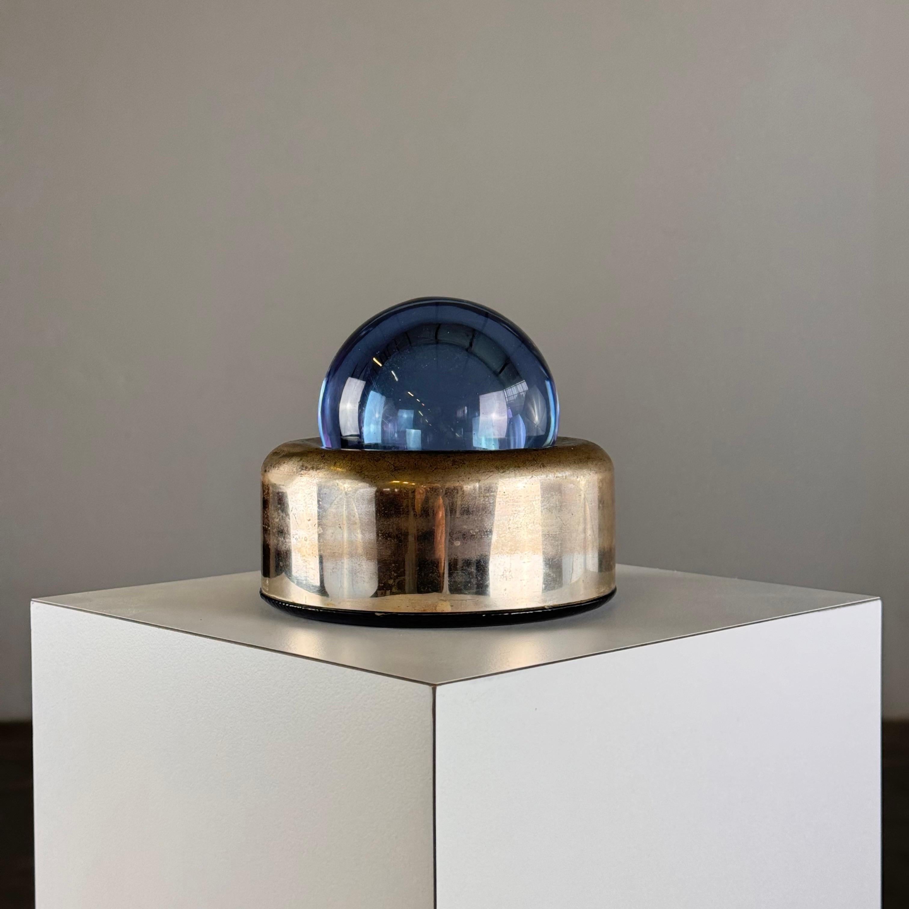 Esta pieza rara y elegante es un testimonio del diseño visionario y el dominio de las formas de Joe Colombo. Elaborada con cristal de Alejandrita, famoso por su capacidad para cambiar de color según la fuente de luz, la 