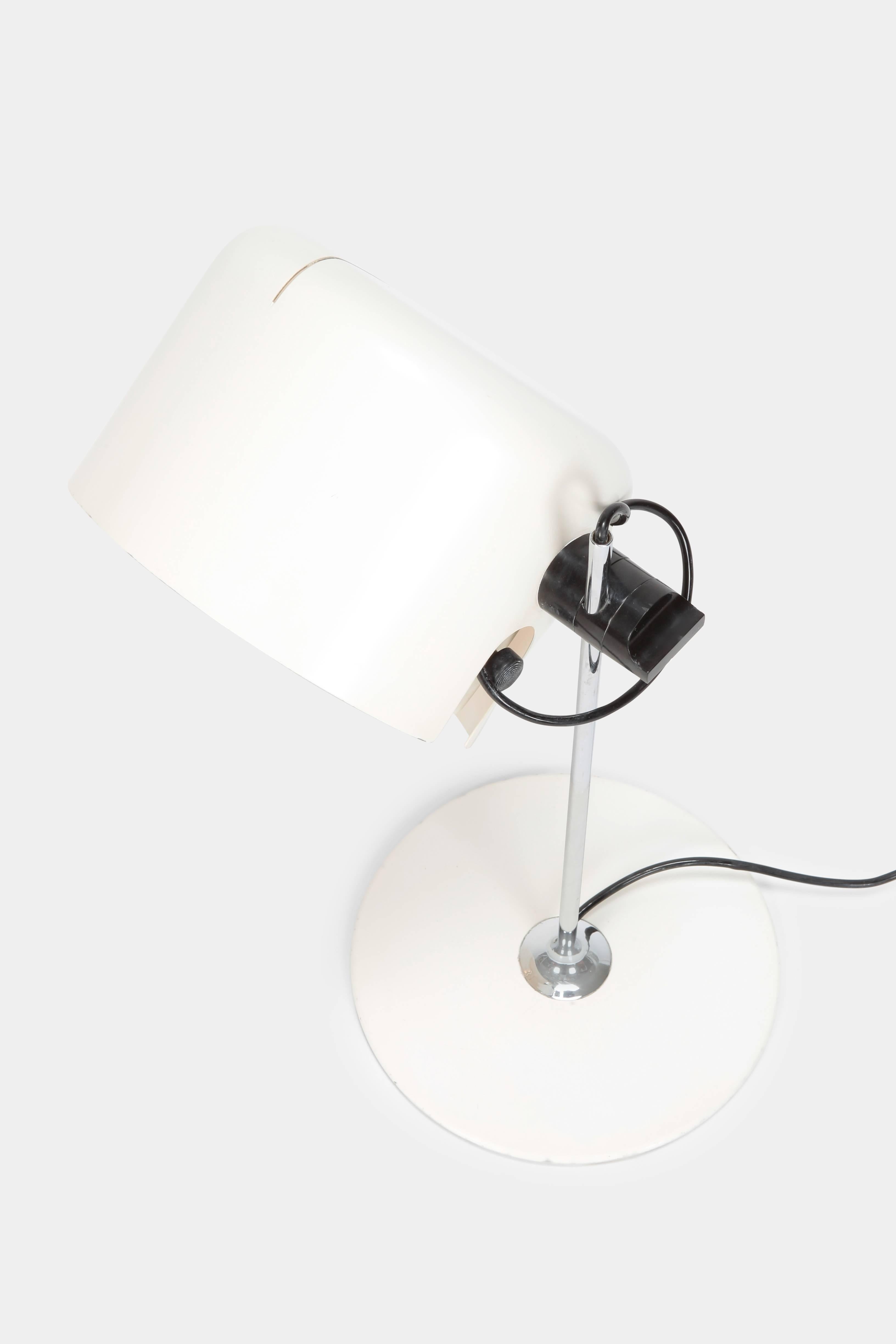 Joe Colombo “Coupe” table lamp manufactured by O-Luce in the 1960s in Italy. Adjustable white lacquered aluminium shade attached to a chrome steel pole on a white lacquered metal base. The back of the shade features a thin slit which creates a