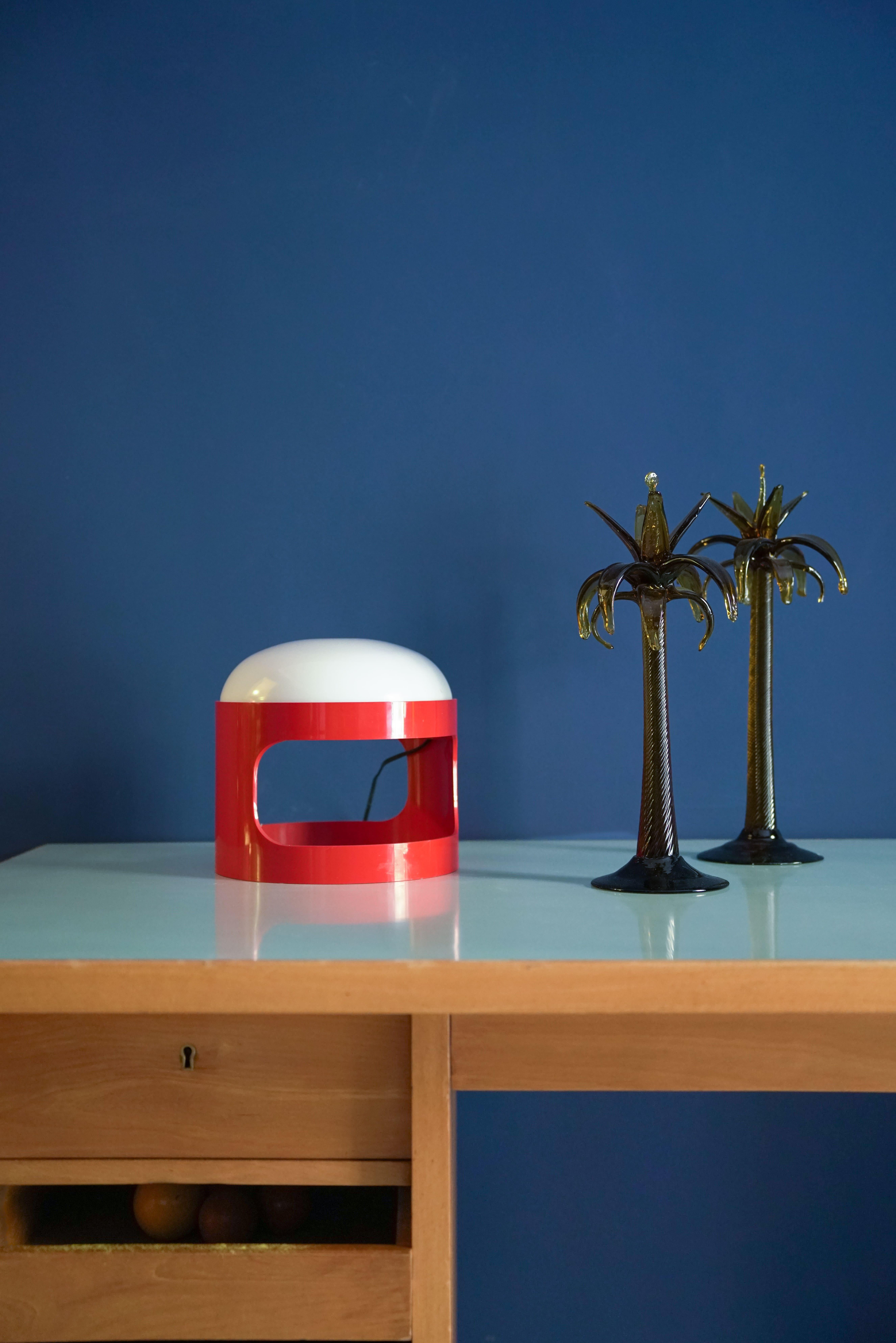 La lampe KD 28, conçue par le célèbre designer italien Joe Colombo pour le fabricant de luminaires italien Kartell, a fait ses débuts en 1967 avec un abat-jour rouge audacieux. Son corps en plastique ABS enveloppe une sphère lumineuse composée de