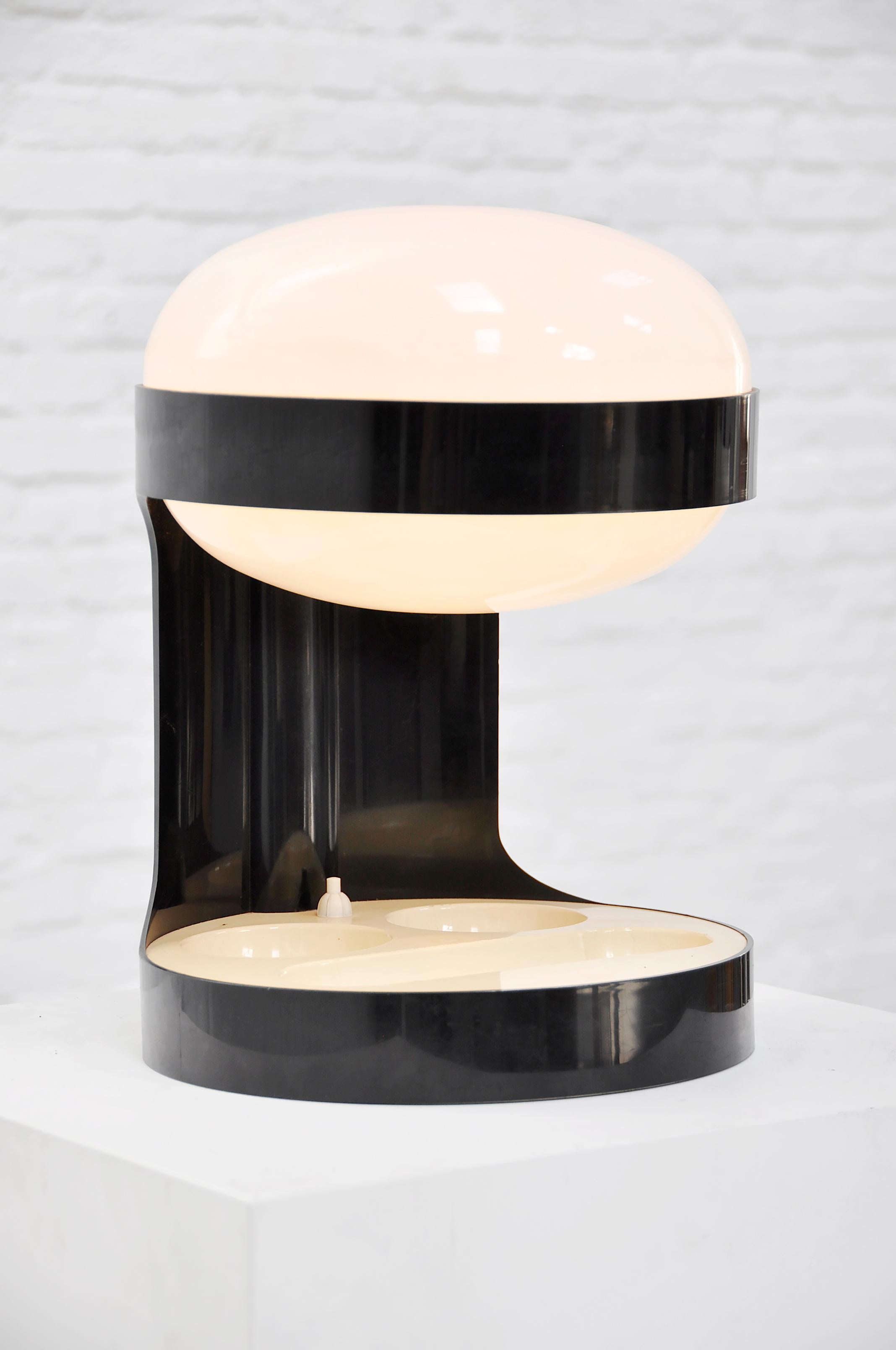 Iconic model KD29 table lamp designed by Joe Colombo for Kartell, Italy, 1967. The lamp is made of a black ABS plastic base and support structure with a white opaline acrylic diffuser. The light source is enclosed within the diffuser, producing a