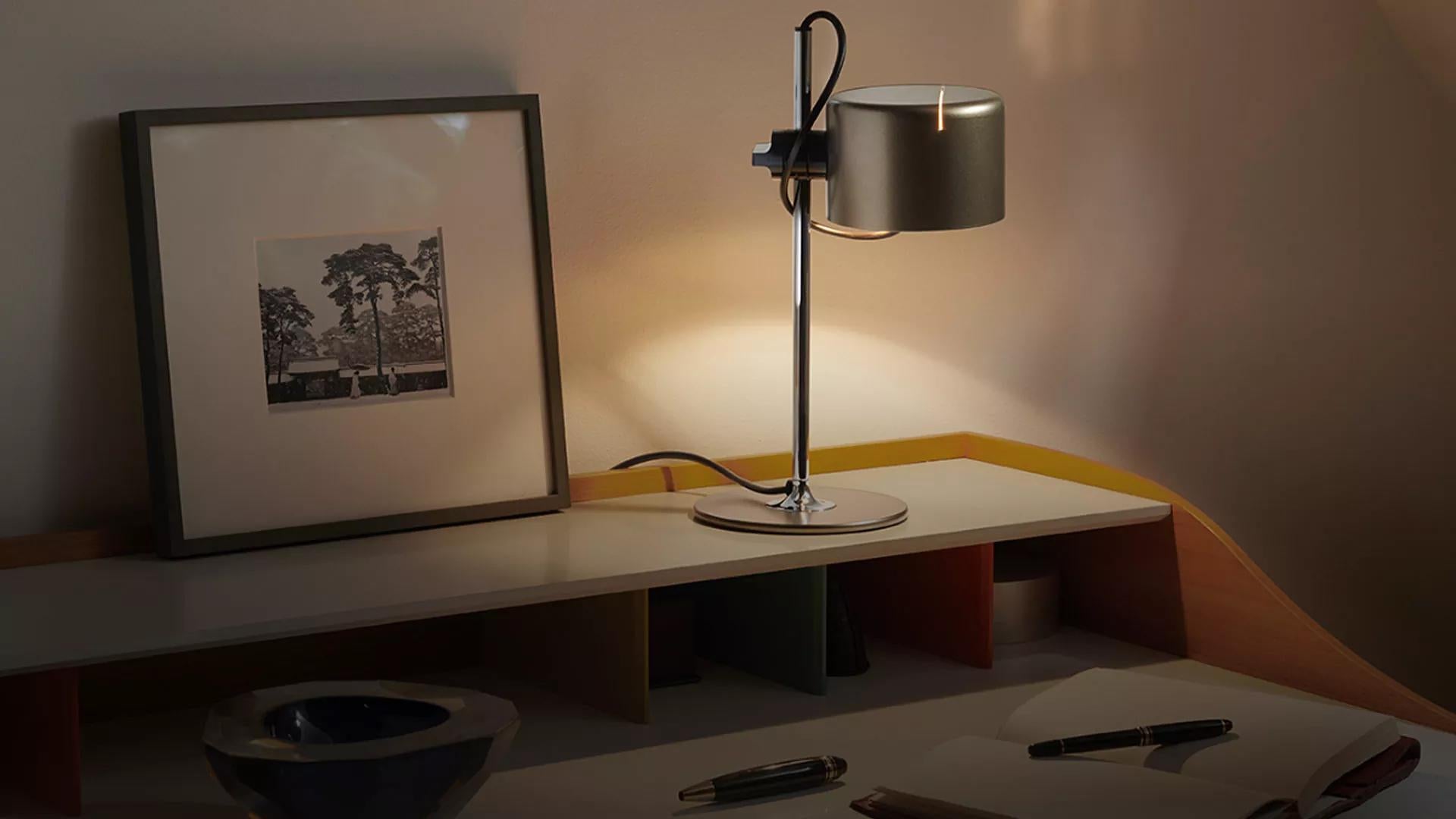 Joe Colombo Model #2201 'Mini Coupé' table lamp in anodic bronze for Oluce. 

Executed in anodic bronze and chrome, this table lamp is a smaller-scale version of one of the most refined Minimalist Italian designs of the midcentury and an icon for