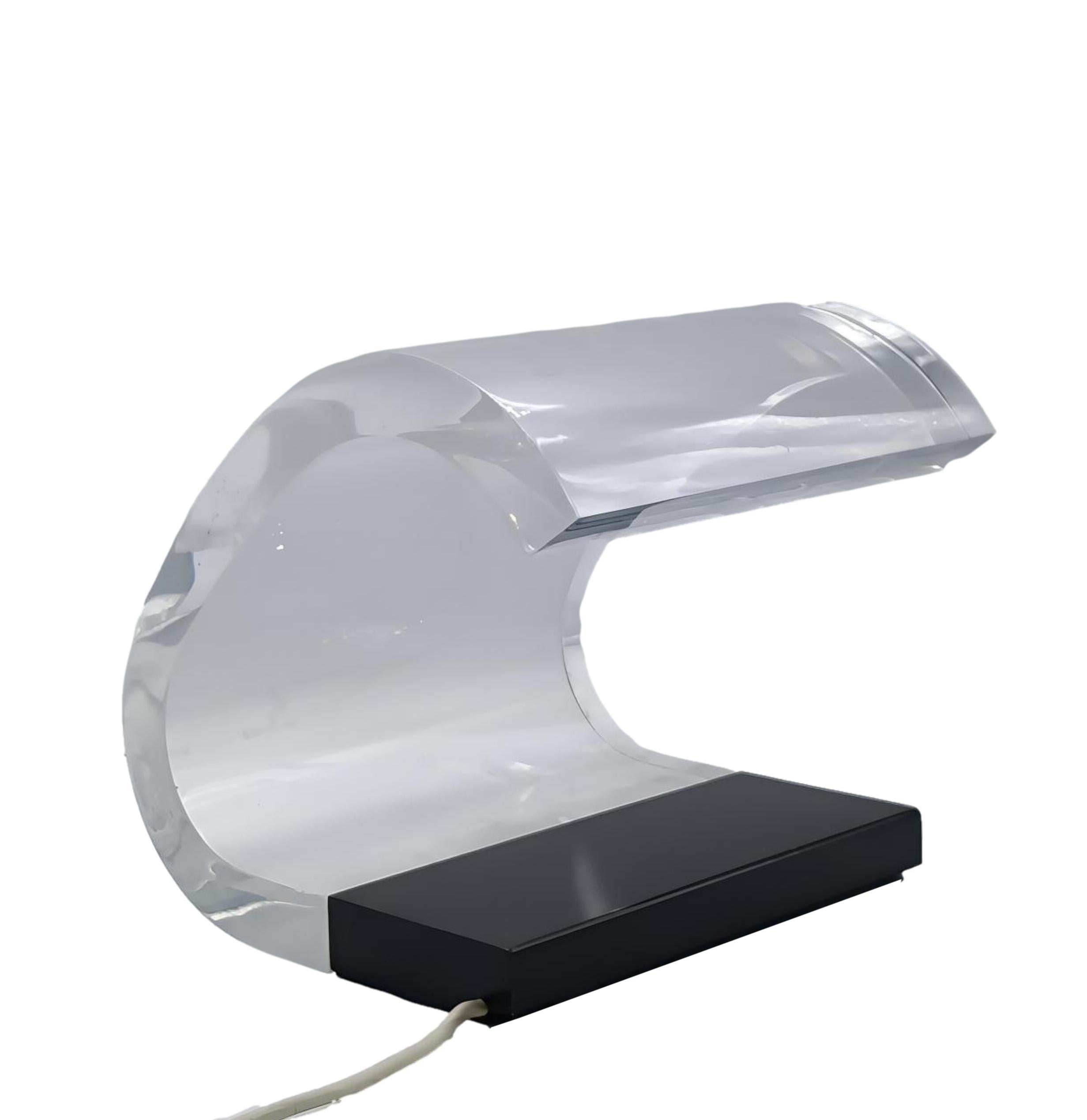 Oluce Acrilica 281 est une lampe de table avec un abat-jour transparent et ondulé fixé latéralement sur une base en acier. Elle a été créée en 1962 par Gianni Colombo et Joe Colombo. La lampe à économie d'énergie est dissimulée dans la base de la
