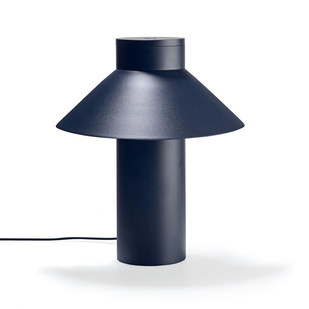 Table lamp designed by Joe Colombo in 1968. 

With its sleek yet optimistic clarity of form; a light, triangular shade seemingly floating off a weighty cylindric base, Italian design icon Joe Colombo’s table lamp nods to Asian heritage, the name