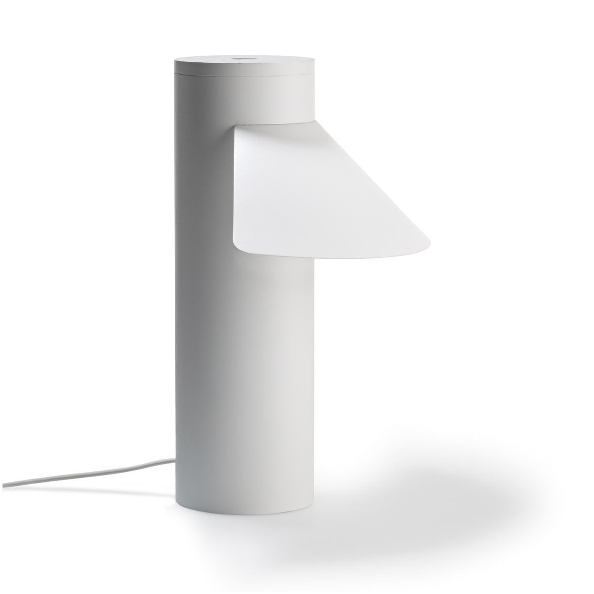 Table lamp designed by Joe Colombo in 1968. 

With its sleek yet optimistic clarity of form; a light, triangular shade seemingly floating off a weighty cylindric base, Italian design icon Joe Colombo’s table lamp nods to Asian heritage, the name