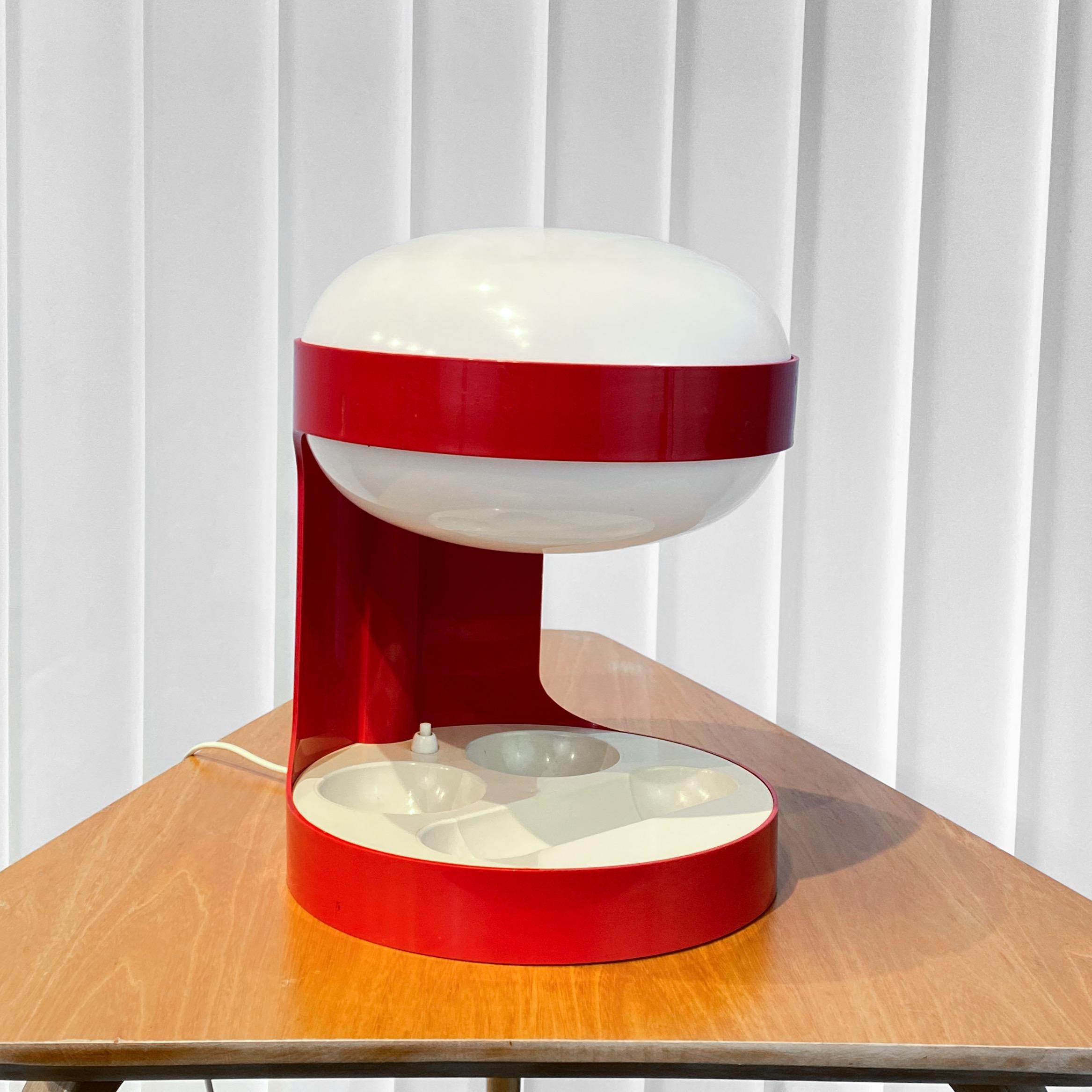 The space-age desk table lamp KD29, designed by Joe Colombo for Kartell in 1967. This example was licensed for production by Husqvarna Borstfabrik in Sweden during the 1970s. Crafted from molded ABS plastic in red and white, it features an