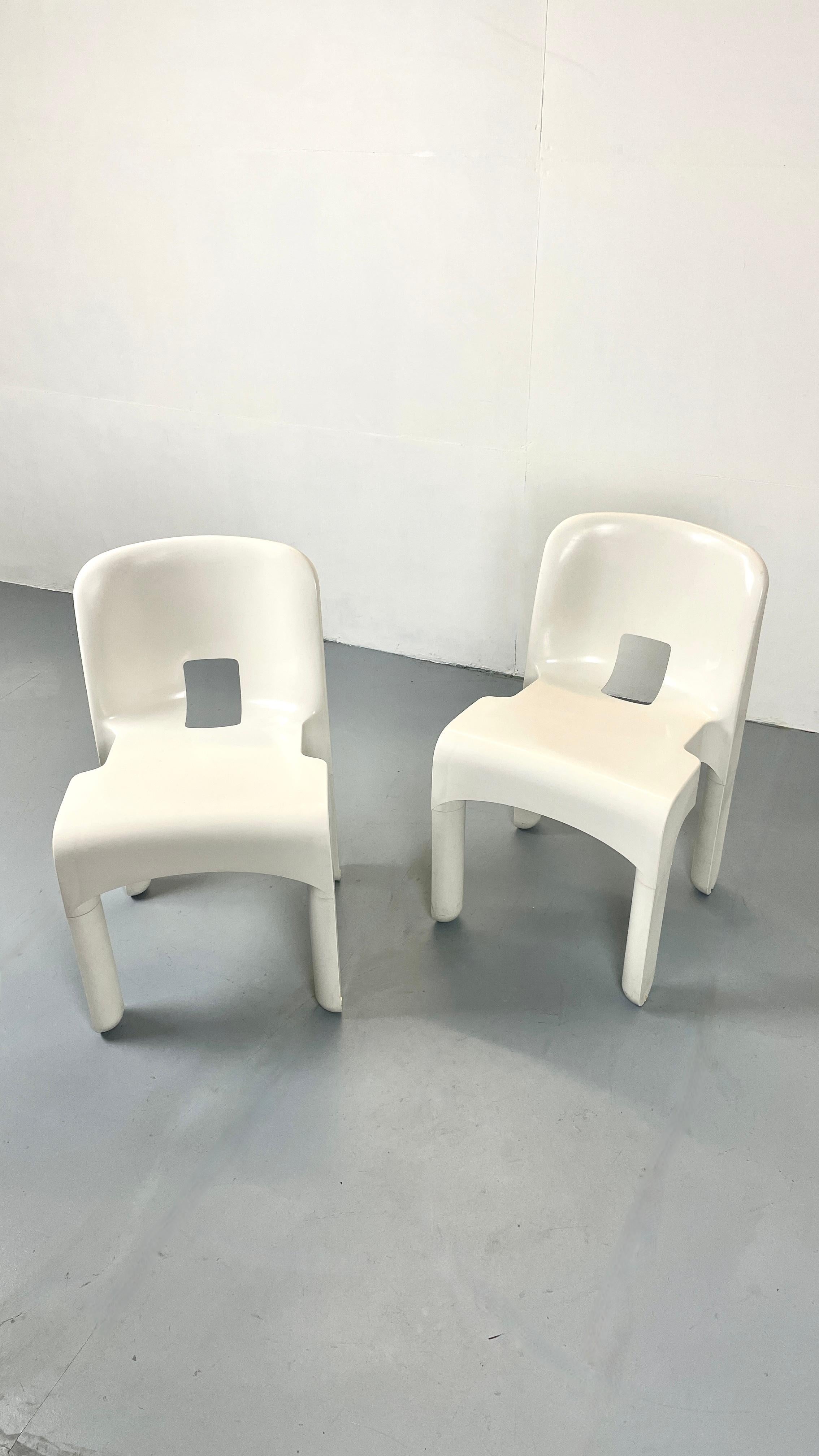 Nice set of two chairs by Joe Columbo. Manufactured by Kartell. 
The Universale chair is one of the first molded plastic chairs created. 
The chairs are in very good vintage condition. Stamped by Kartell, Italy.

A true Space Age Icon.