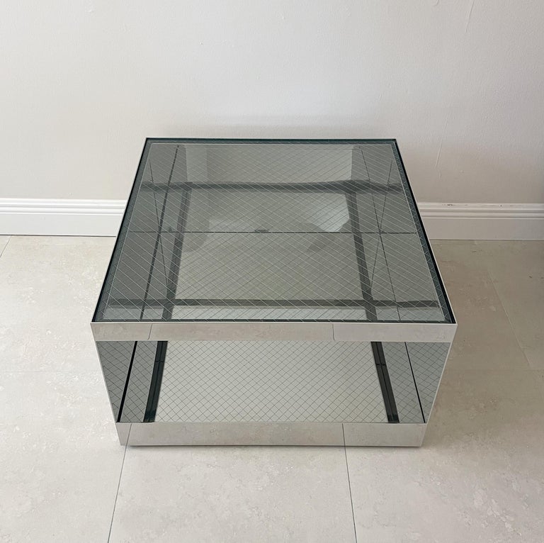 Polished stainless steel with safety glass tables designed by Joe D’Urso for Knoll. This low rolling cube form table is Model 6027T and is from the Minimalist line D’Urso designed for Knoll in the 1980s. Table rests on recessed casters. Original