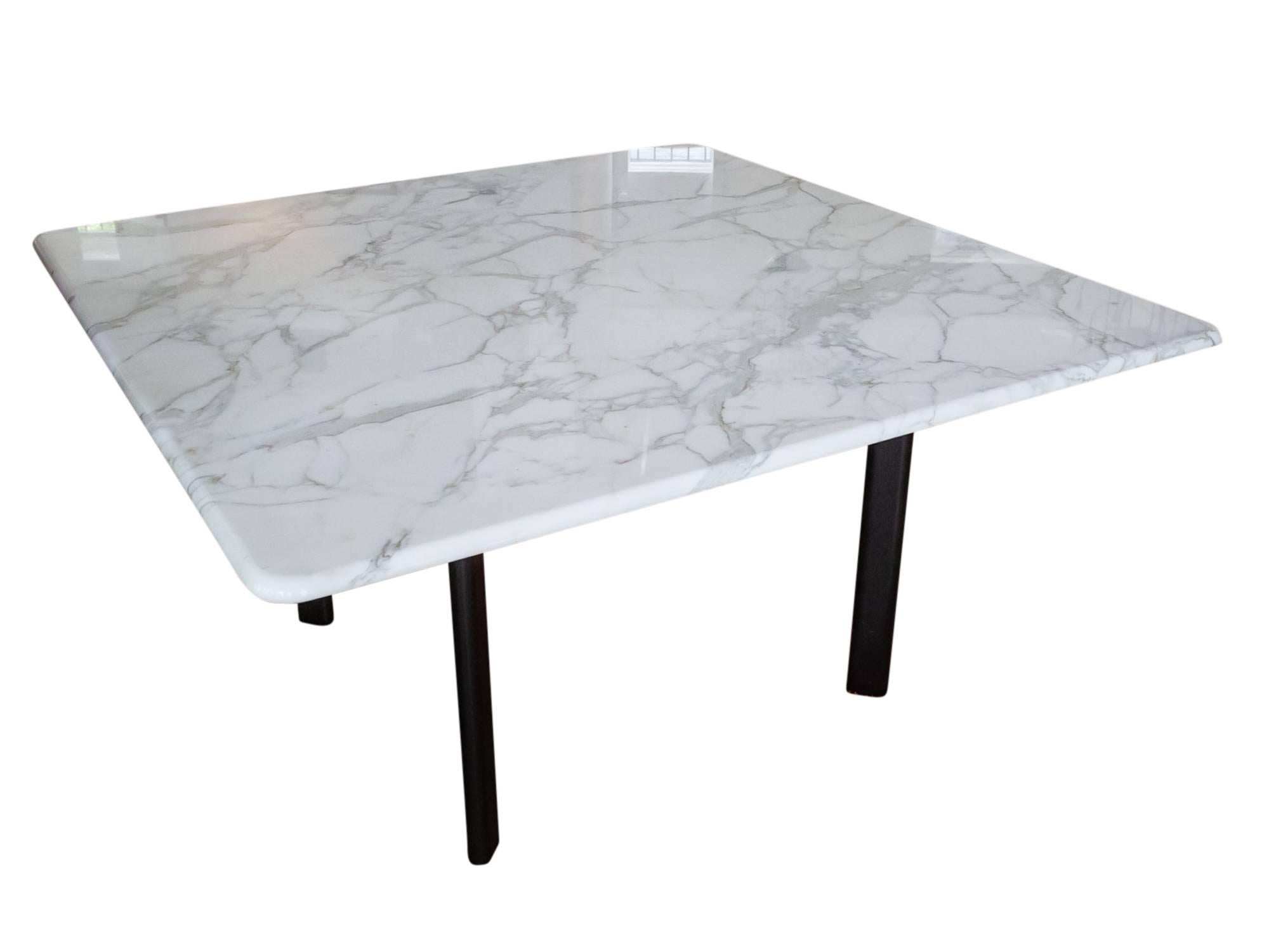A minimalist dining table designed by Joe D'urso for Knoll, circa 1980s. Featuring a square Carrara marble top with bullnose edge supported by a black enameled base consisting of four tubular metal legs. All in excellent condition. Knoll