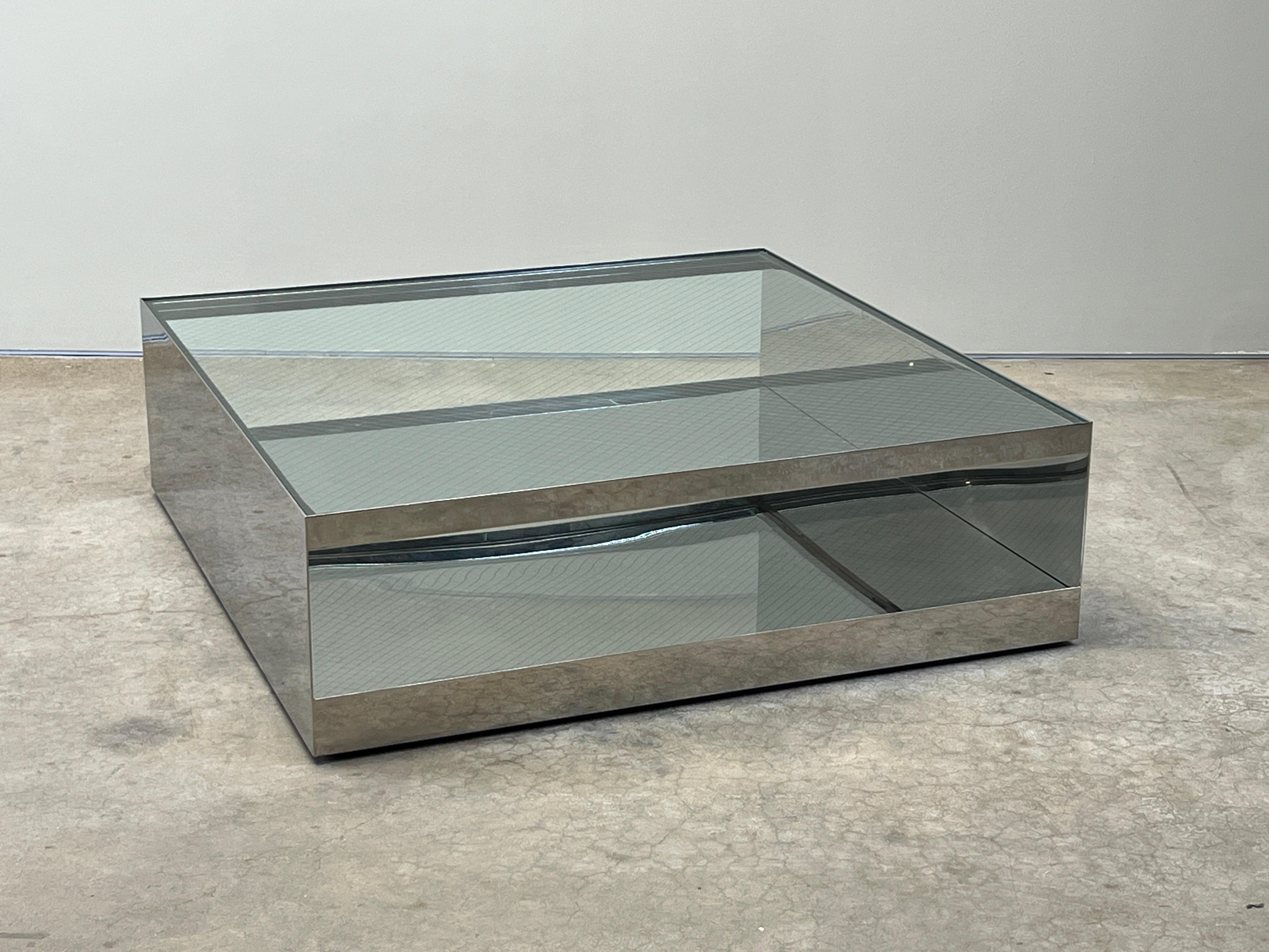Une table en acier inoxydable poli avec un plateau en verre de sécurité. Conçu par Joe Durso pour Knoll.