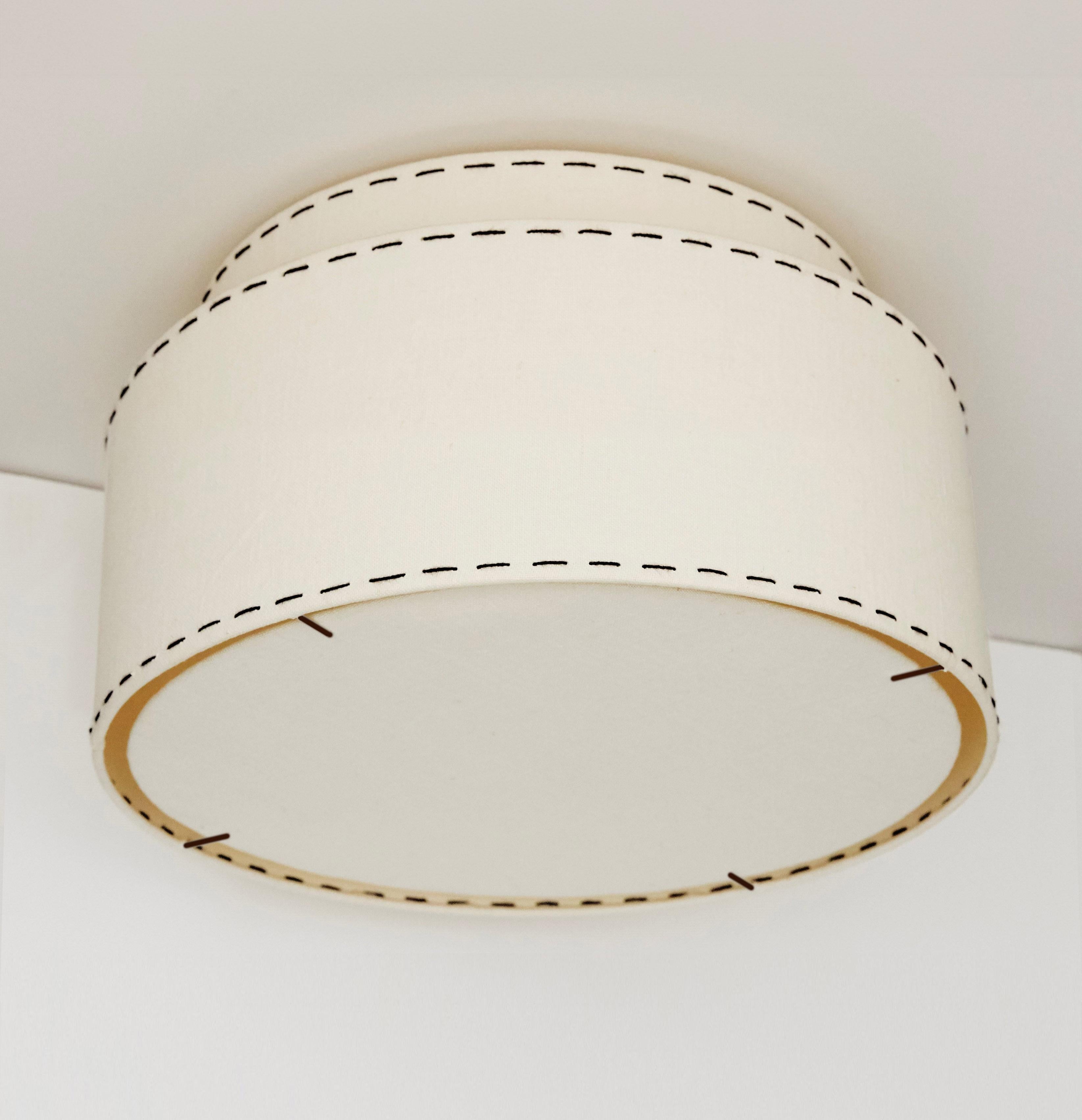 
This classic, tailored, double ceiling lamp, inspired by old Hollywood and menswear is reminiscent of the 1940s and the early simplicity of Art Deco. Its clean shape is the perfect foil for our hand crafting and signature stitching to both tiers of
