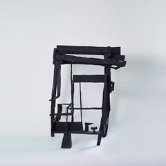En el jardín al atardecer, escultura geométrica abstracta negra de madera