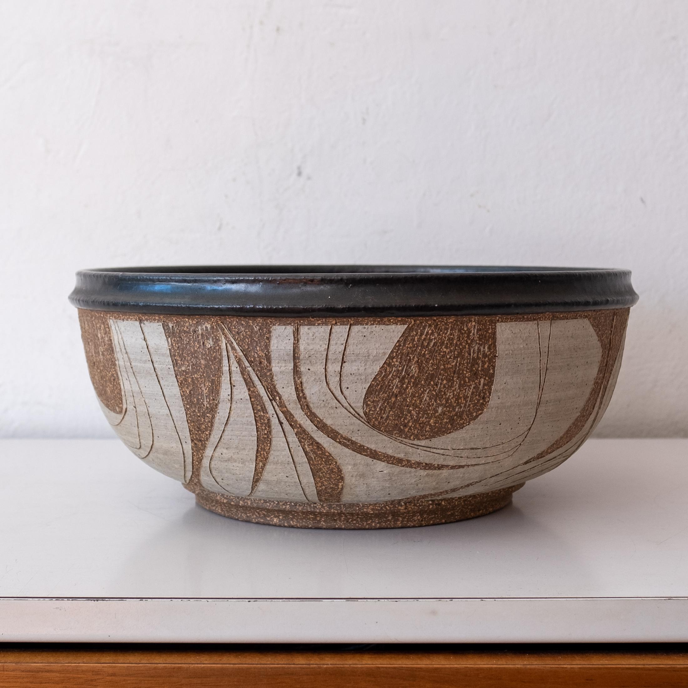 Incredible wheel-thrown large ceramic bowl by California artist, Joel Edwards. Incised abstract pattern around the circumference of the bowl. Glazed interior and bottom. Signed on the bottom. USA, 1960s 

Edwards was based in Los Angeles, CA. He