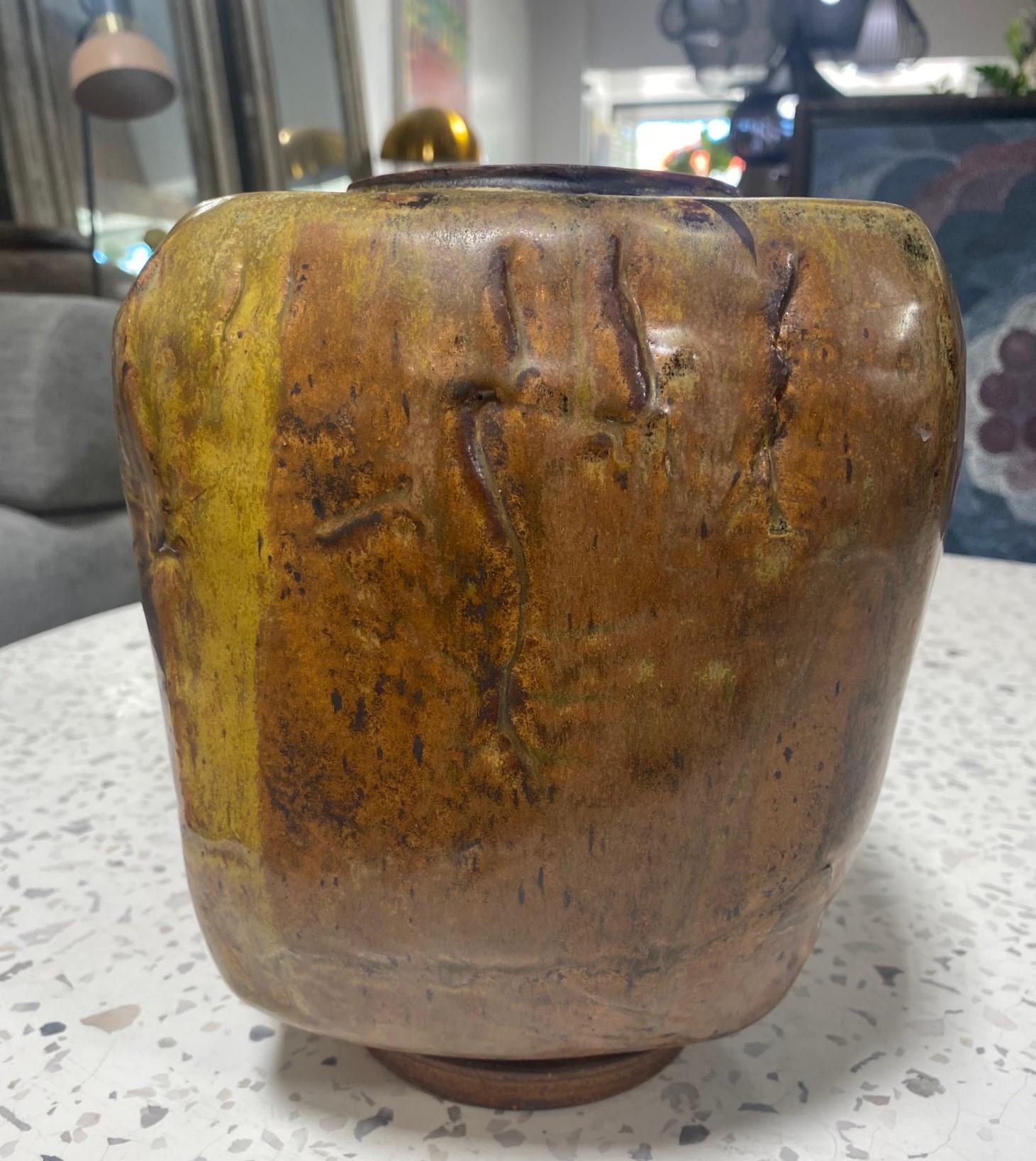 A wonderfully designed, quite heavy brutalist sculptural vase by famed American California potter, Joel Edwards. This piece features a sumptuous glaze of varying dark and shimmering colors.  

Edwards was a student of Peter Voulkos at Otis. He also