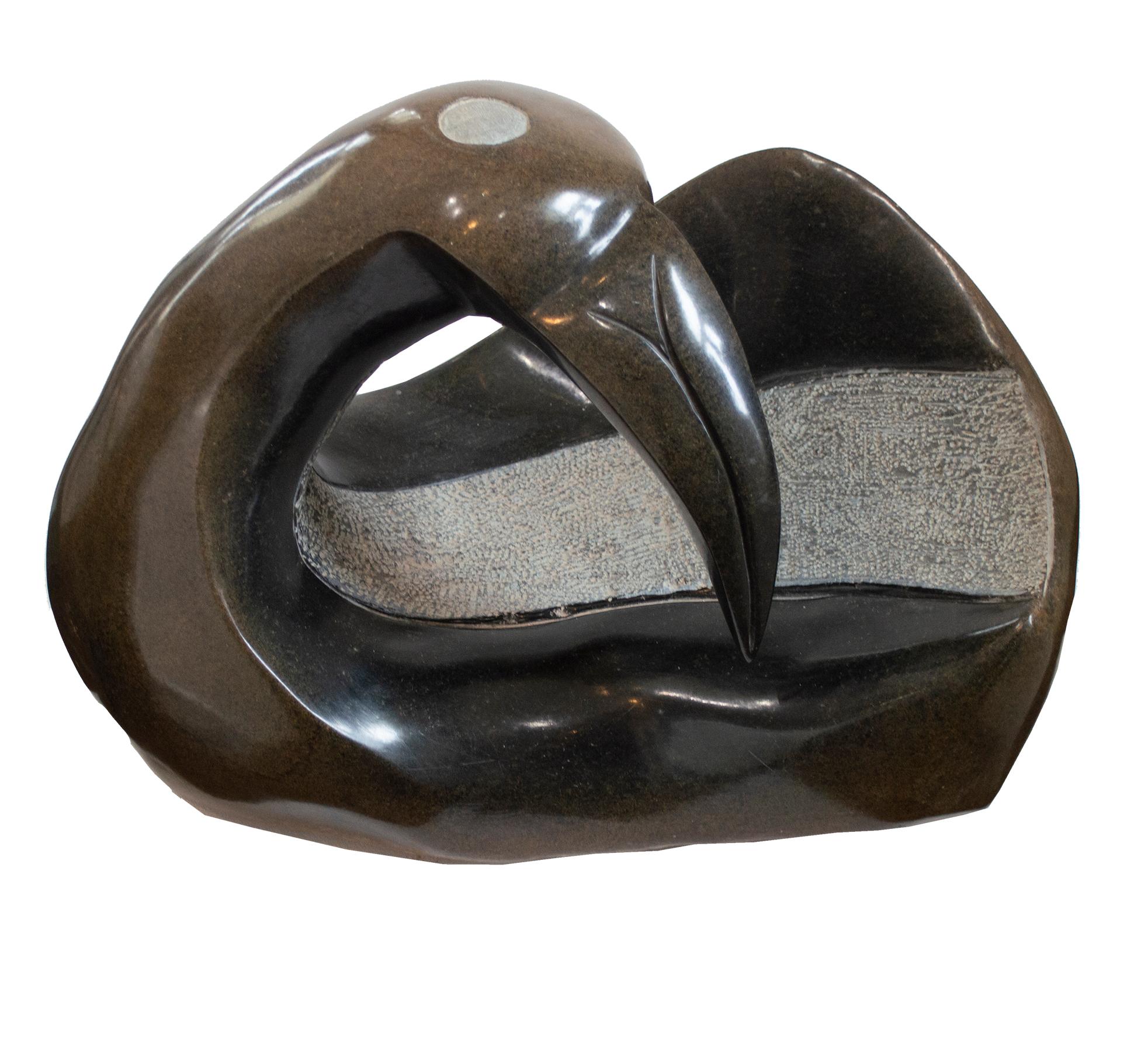 landing Dove" est une sculpture originale en pierre opale serpentine signée par l'artiste contemporain zimbabwéen Joel Nhete. L'artiste présente dans cette sculpture la figure très abstraite d'un oiseau, qui penche la tête en arrière, les ailes