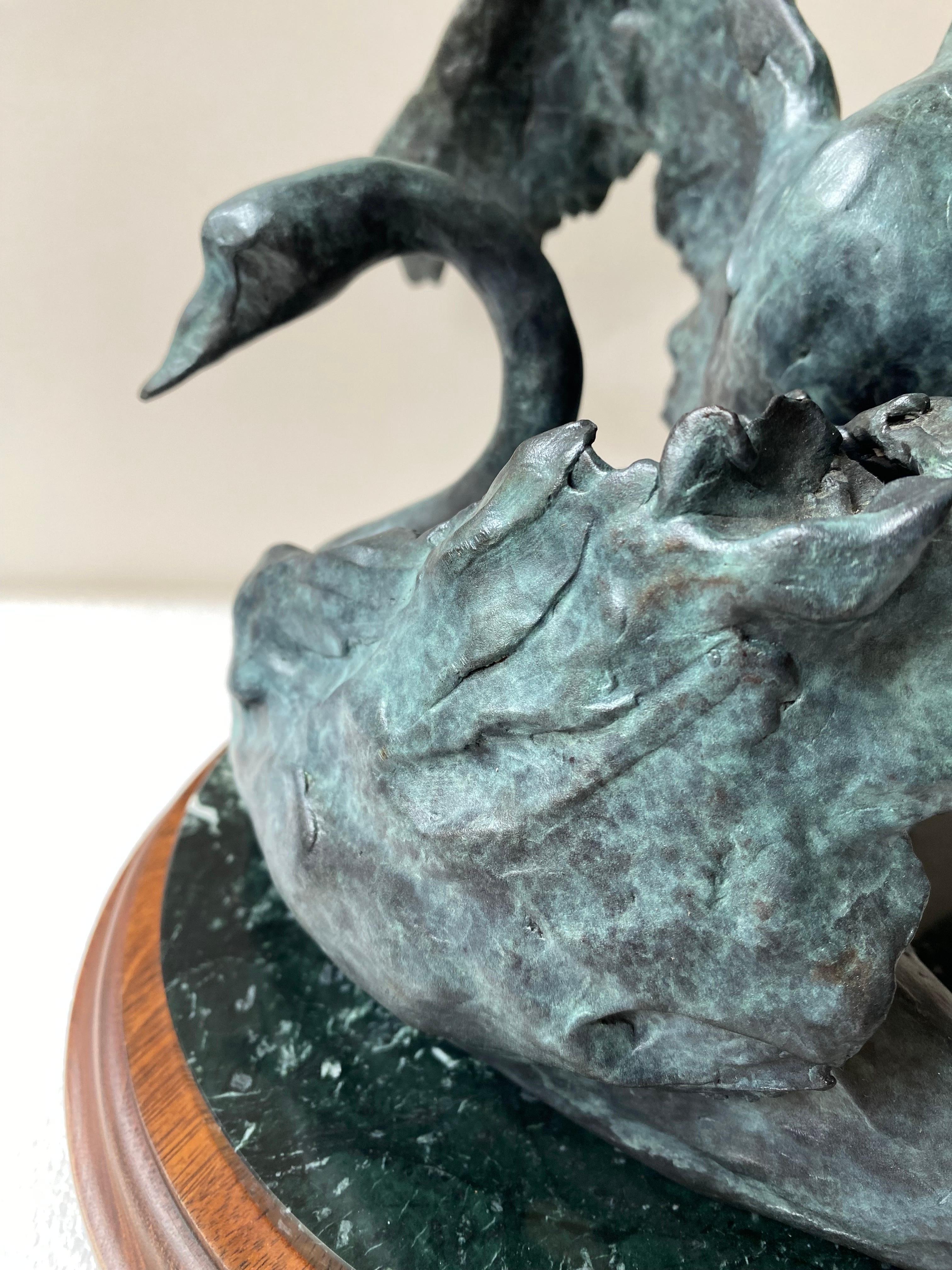 Joffa Kerr bronze sculpture of a pair of Swans on a round marble base and wood base. Beautifully done, small series. This one is numbered 3/15 in great shape with no flaws.