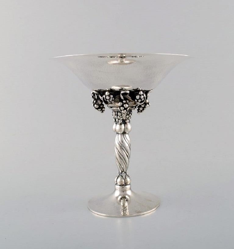 Johan Rohde for Georg Jensen. 
A pair of grape centrepieces in hammered sterling silver. Model number 263. 
Dated 1925-1932.
In perfect condition.
Early Stamp.
Weight: 625 grams each.
Height: 19 cm. Diameter: 18 cm.
 