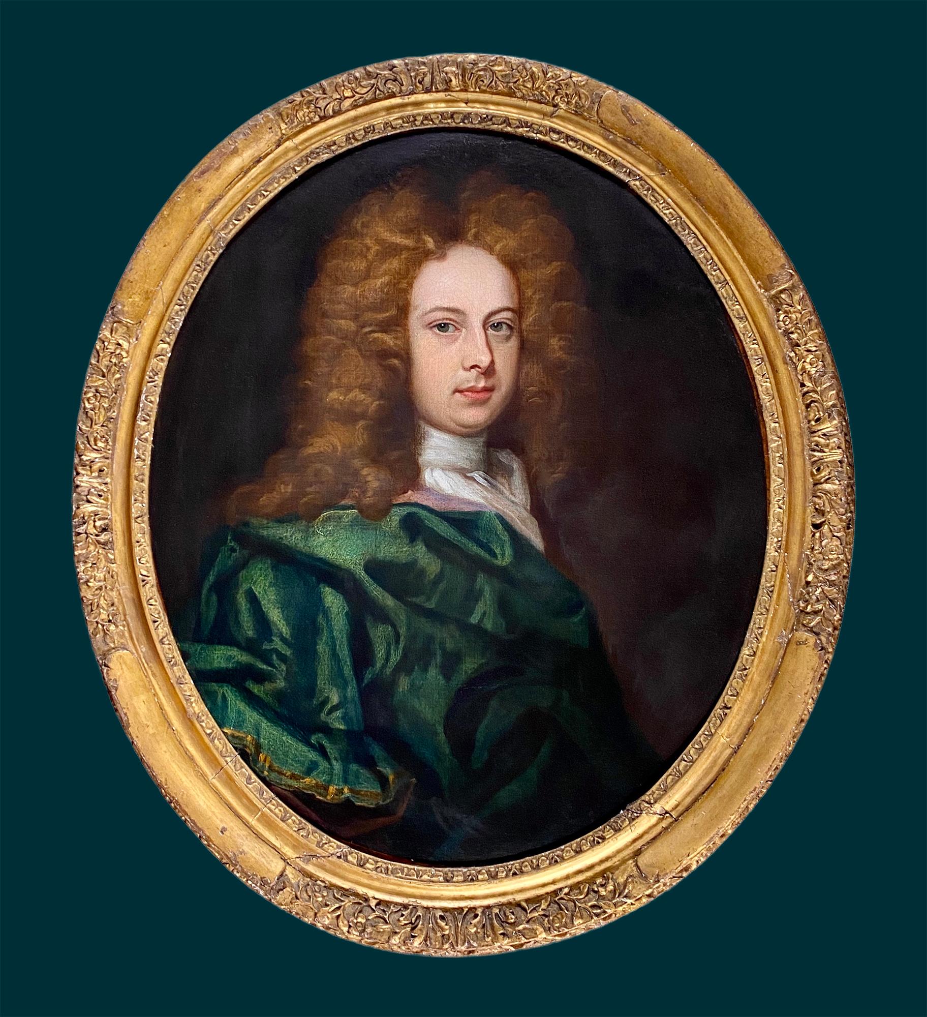 A fine, sensitively rendered and highly decorative portrait of a handsome gentleman circa 1690 by an artist in the circle of Johann Kerseboom. The handsome green eyed young gentleman is pictured half length within the oval and with his head slightly