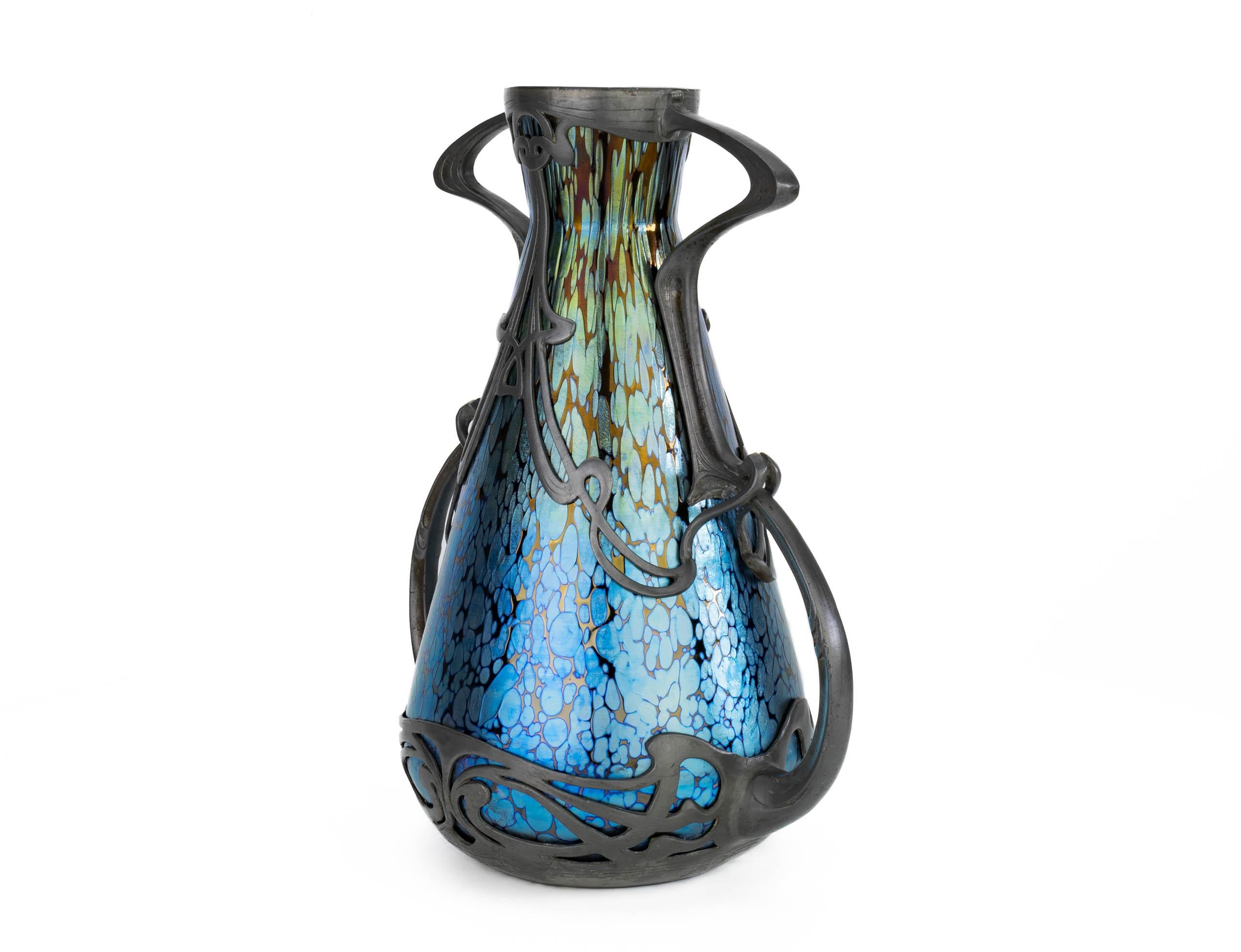 This vase was created in the heyday of Art Nouveau around 1900 – 1905 through a collaboration between Johann Loetz Witwe from Austrian Bohemia and Boudon & Klähr from Paris. This creation is a perfect marriage of Austrian Jugendstil and French Art