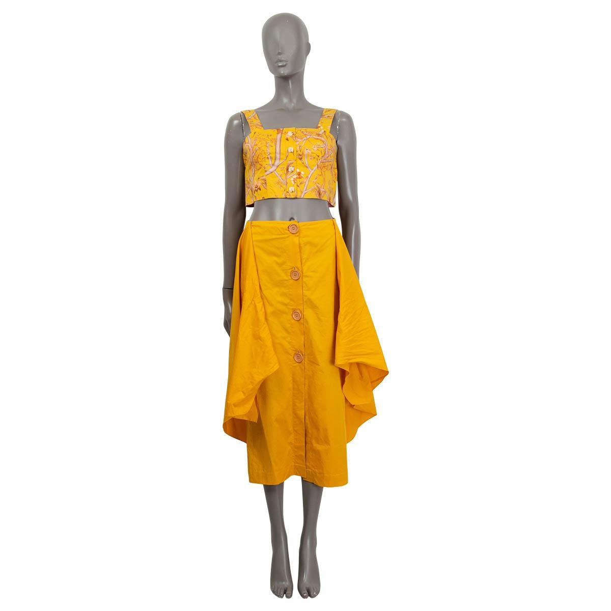 100% authentic Johanna Ortiz 'Romantic Travels' top in curry yellow, salmon and nude cotton (100%). Features four faux buttons on the front and a bow at the back. Opens with two hooks on the back. Unlined. Has been worn and is in excellent
