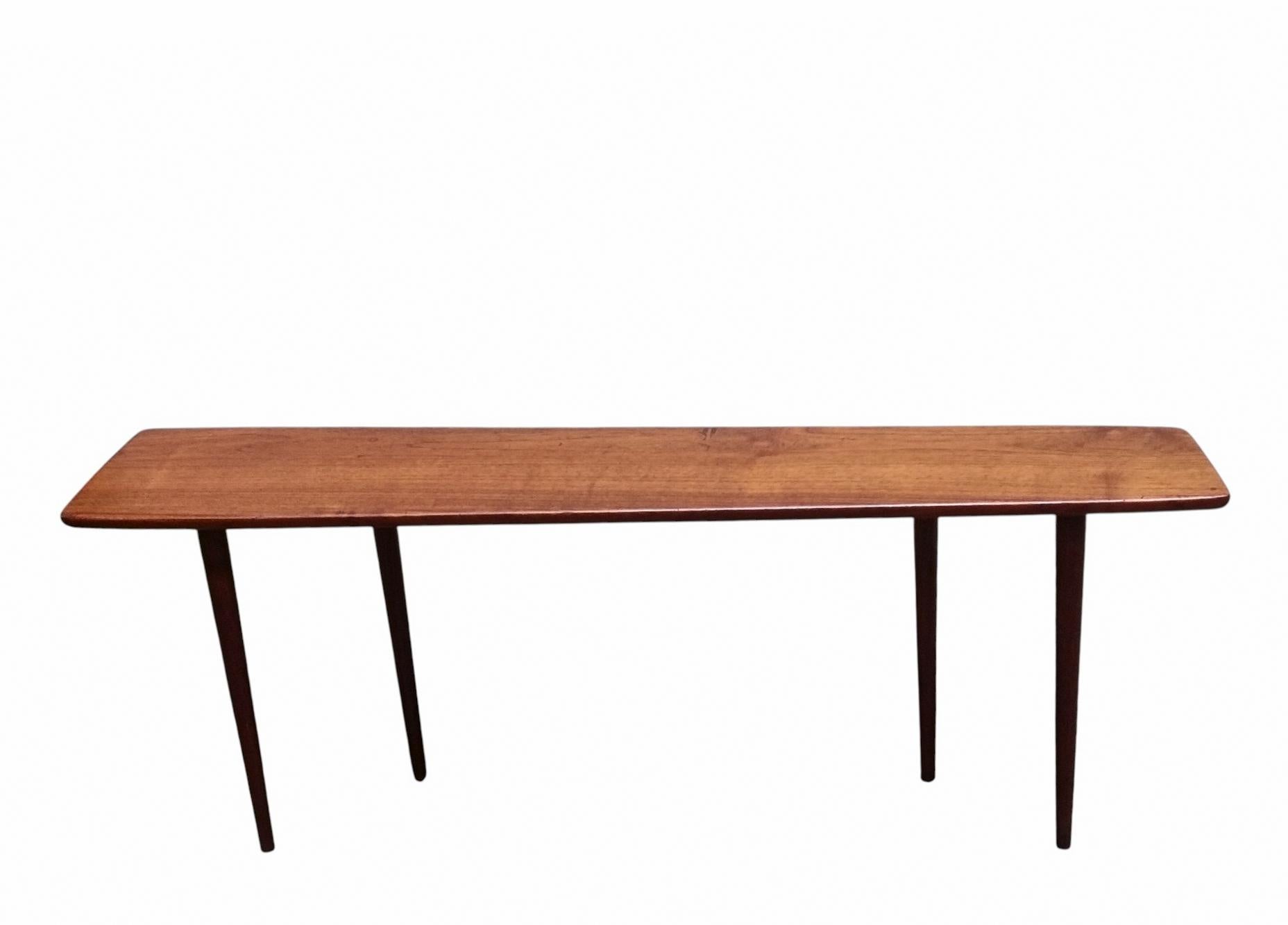 Raro tavolino progettato da Johannes Aasbjerg in teak massello dalla forma affusolata. Grazie alla sua superficie poco profonda, puo' essere posizionato ovunque anche in un corridoio.