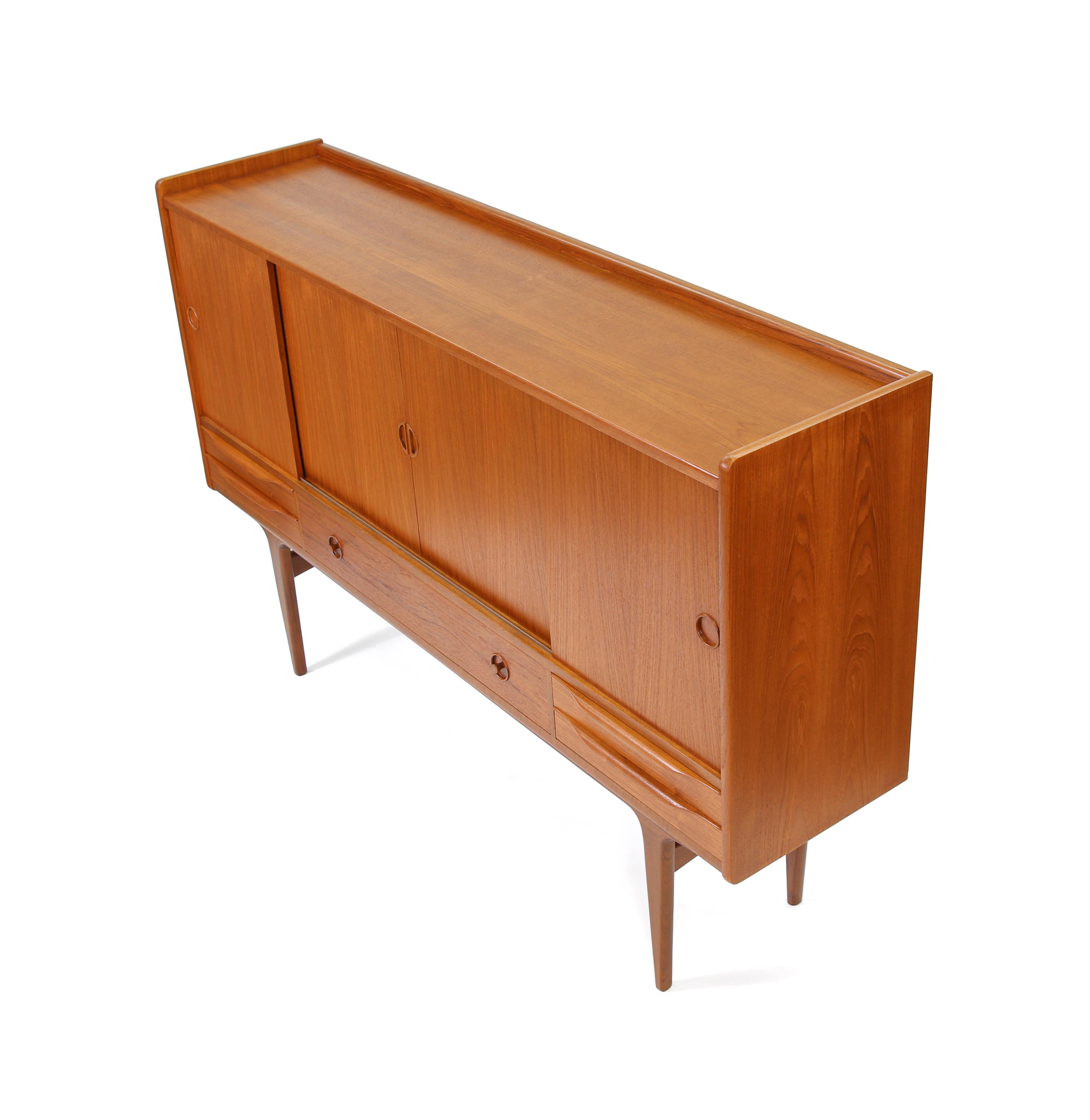 Johannes Andersen Attributed Danish Mid Century teak highboard credenza

A very nice Danish mid-century teak highboard credenza recently imported from Denmark. Refined design with a variety of pull styles on the sliding doors and lower drawers.