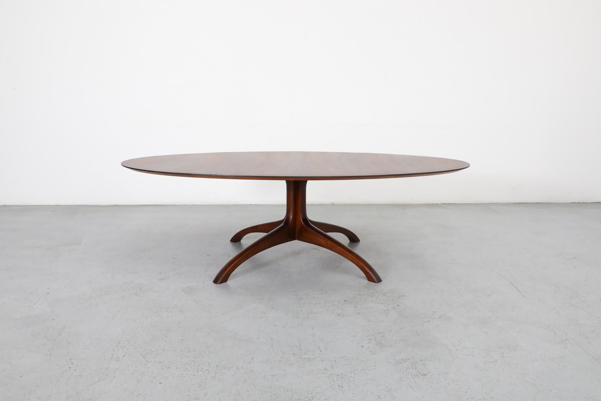 Magnifique table de salon ovale en bois massif avec un plateau en bois de rose assorti et une base moderne en forme de griffe. Le bord conique sur le dessus et le dessous donne à la table un aspect léger. Magnifique figuration du bois, avec des tons
