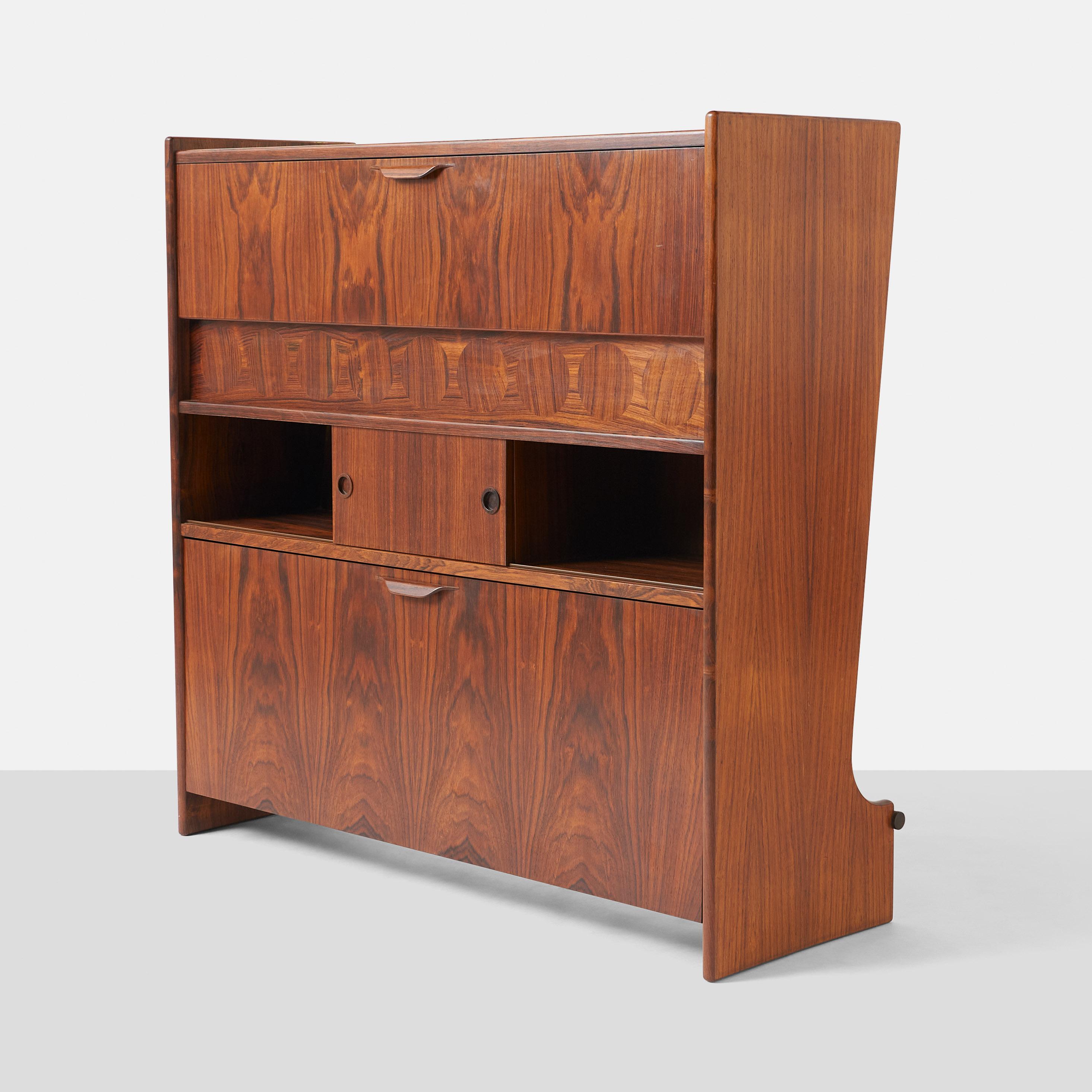 Beautiful freestanding rosewood bar, model #SK661 by Johnnes Andersen for J. Skaaning & Søn. Fold-down front door reveals a hidden bar with glass shelves and room to store glasses and bottles.