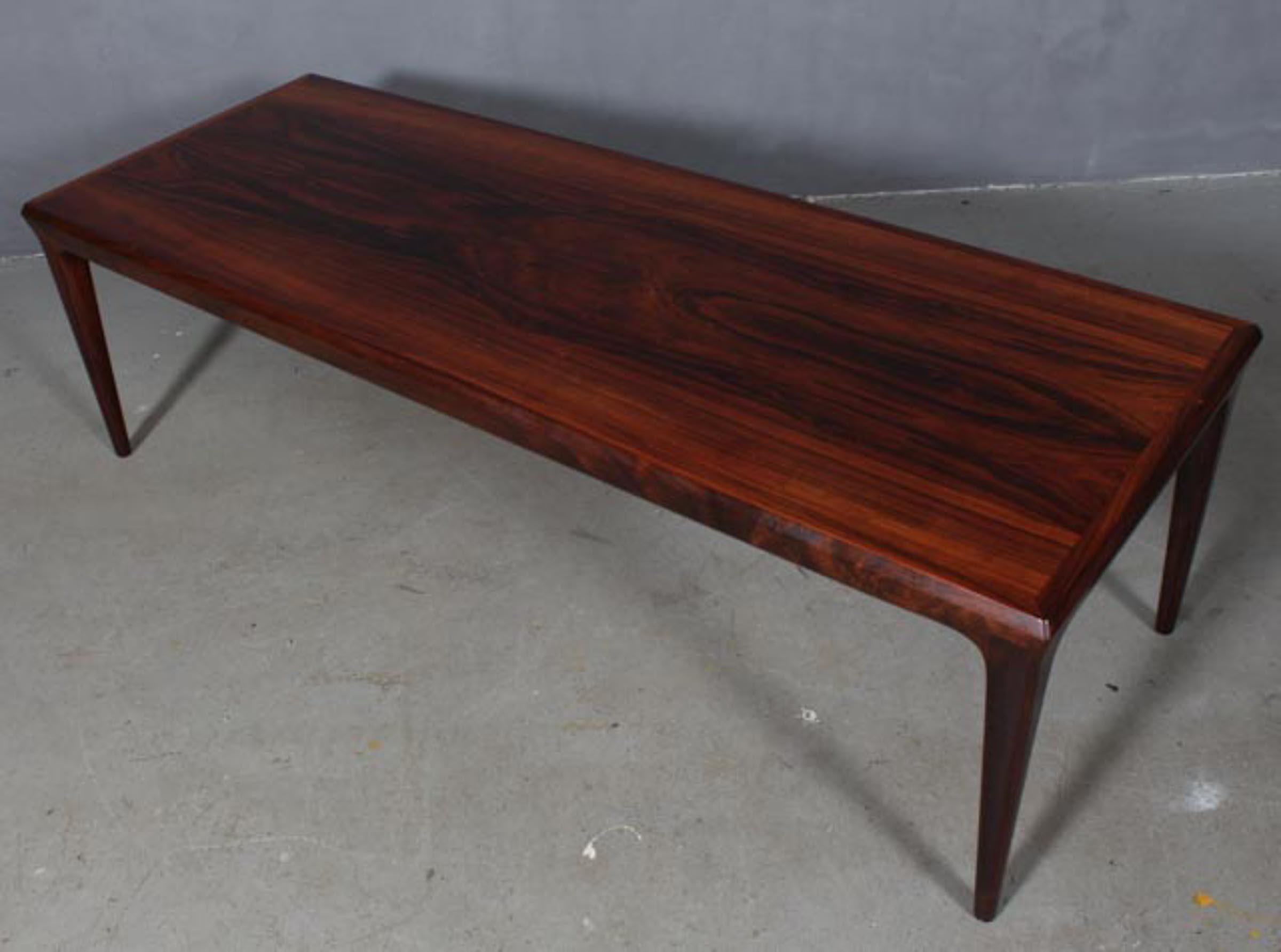 Johannes Andersen coffee table in partly solid rosewood.

One extension leaf with grey Formica.

Made by Uldum.
 
