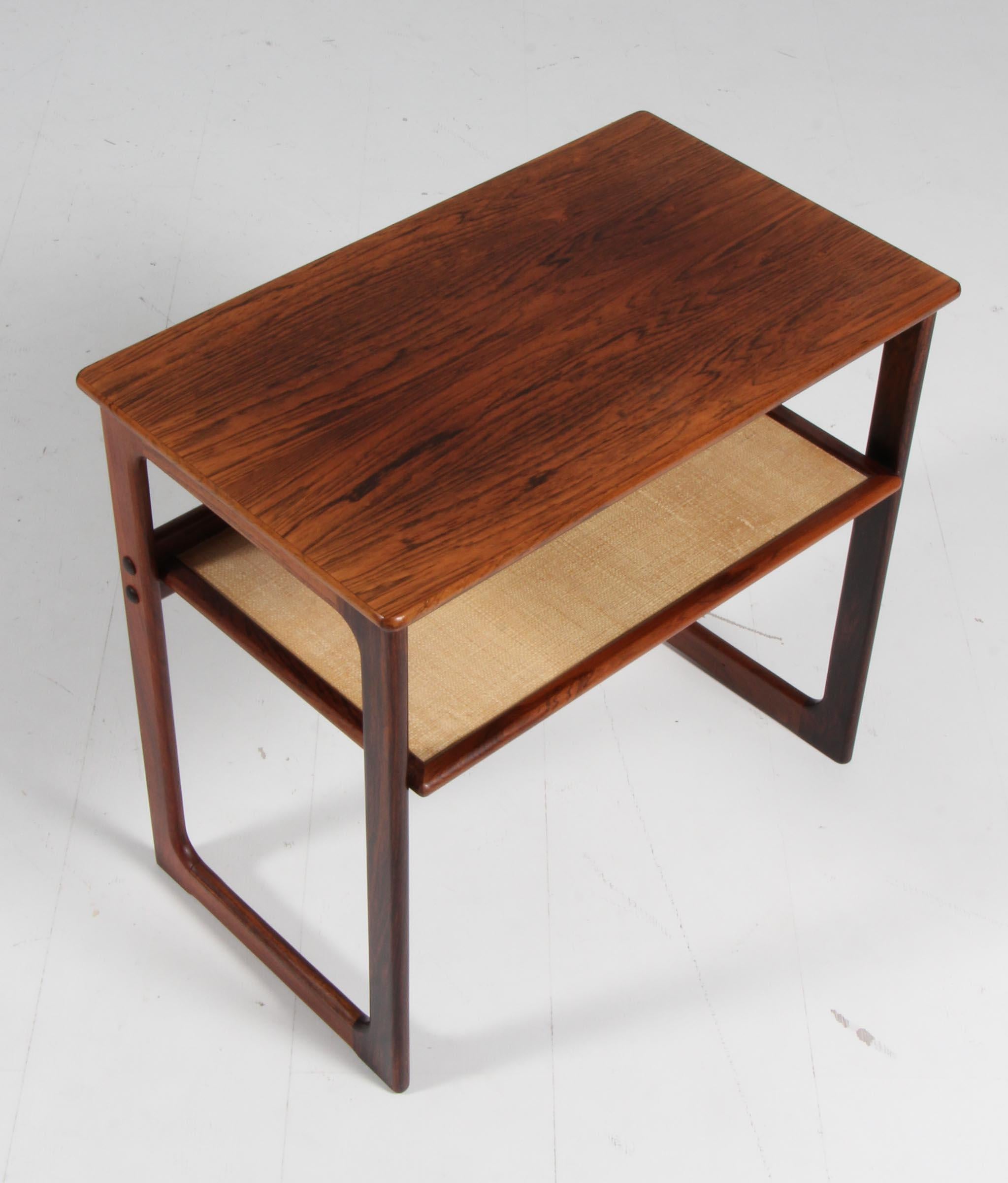 Johannes Andersen side table in partly solid rosewood, with cane shelf.

Made by CFC.