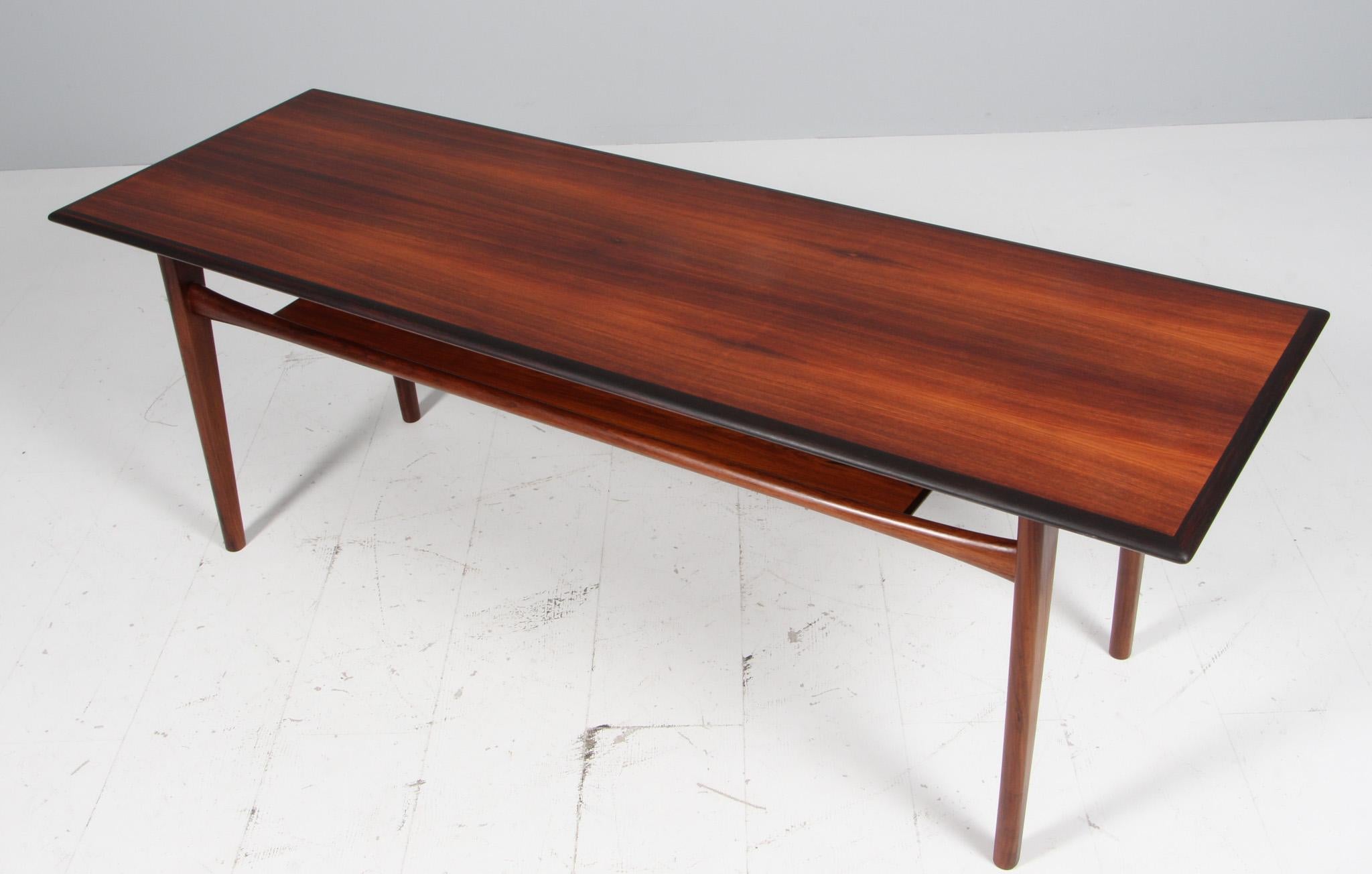 Johannes Andersen coffee table in partly solid rosewood.

Newspaper shelf.

Made by CFC.