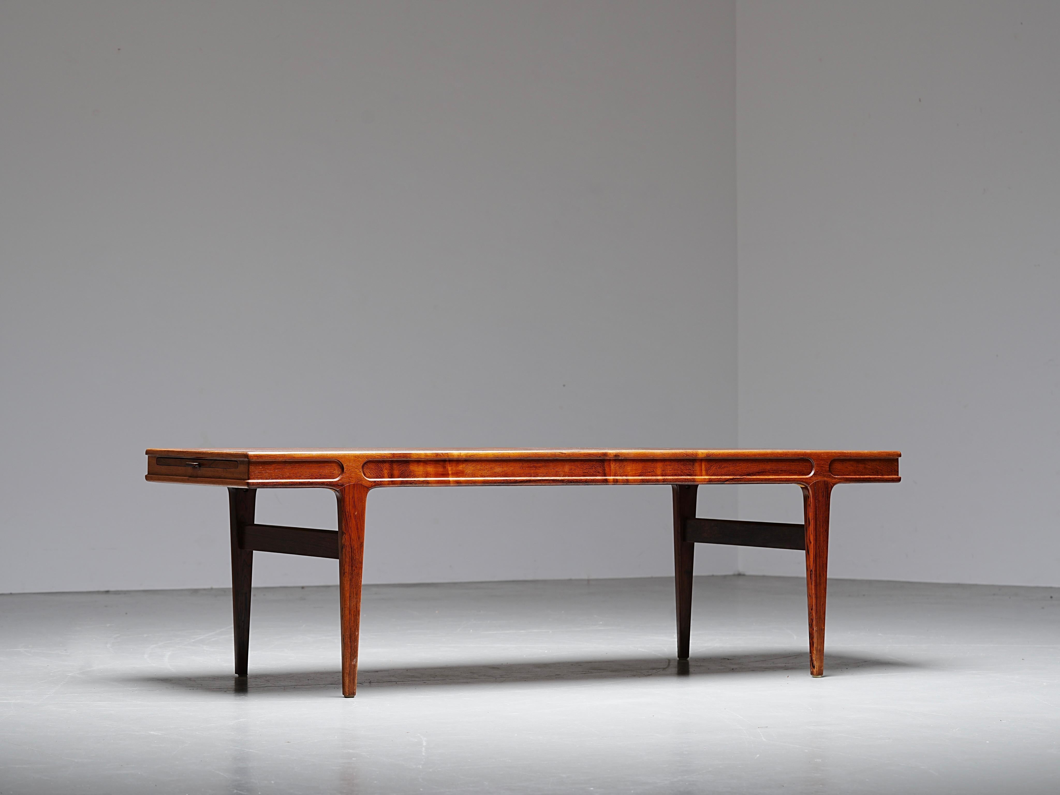 Teak coffee table designed by Johannes Andersen, Denmark, 1960s.
Elegant carved frame with Andersen’s signature soft edges and sculpted legs.
Practical pull-out trays with black laminate surfaces at both ends.
A refined piece of Danish modern