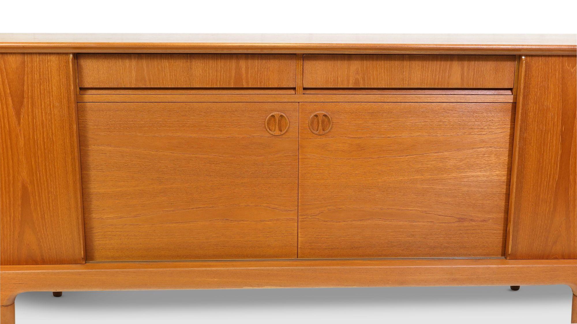 Mid-century teak credenza designed by Johansen Andersen for Clausen Sons, Denmark, 1960s. The sideboard is handcrafted of book-matched old-growth teak with four sliding cabinet doors and two drawers with sculptural pulls. The doors open to reveal an