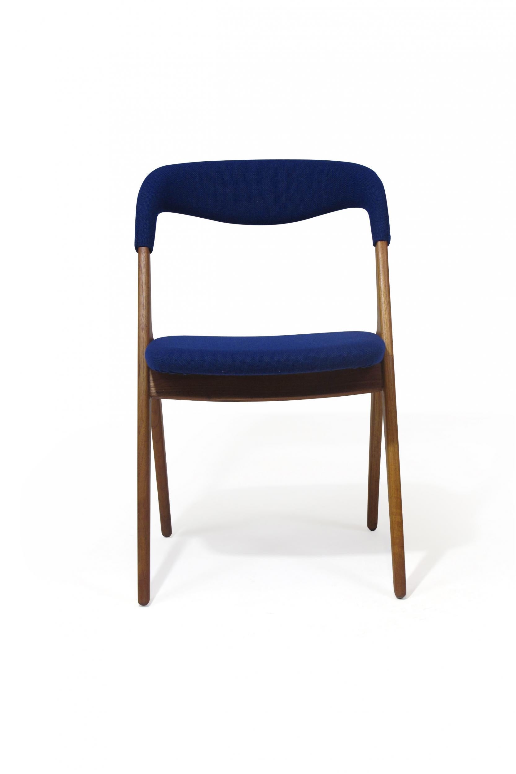 Danish teak dining chairs designed by Johannes Andersen for Vamo Sonderborg, model 'Sonja' Denmark circa 1960. The chairs are crafted of solid teak frames with a dramatic curved backrests. Newly upholstered in a blue wool.