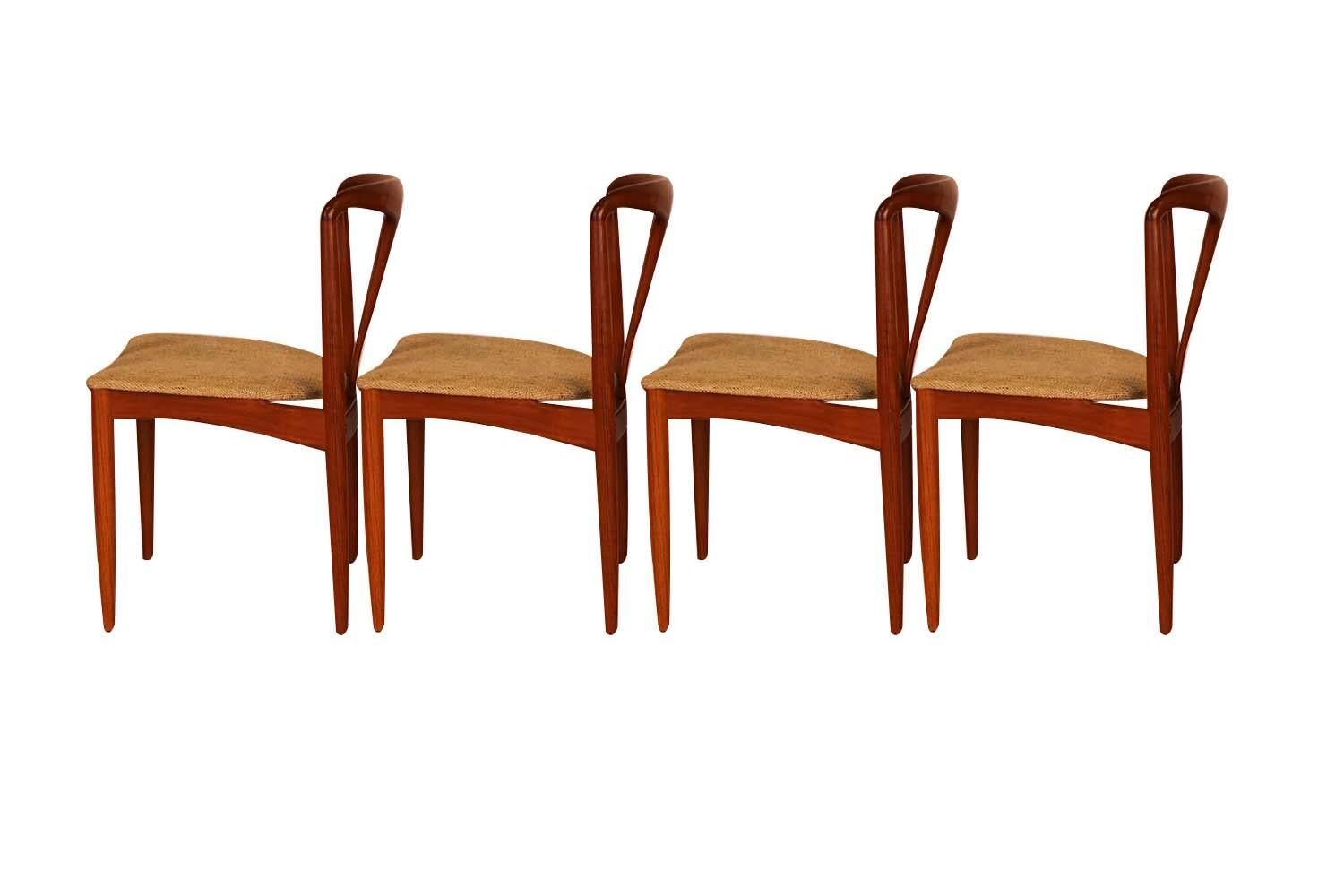 Set of 4 teak Danish modern 'Juliane' dining chairs by famous designer Johannes Andersen for Uldum Møbelfabrik, made in Denmark, circa 1960s. Superbly crafted in rich solid teak frames, remarkably notable are the carved sculpted backrests with
