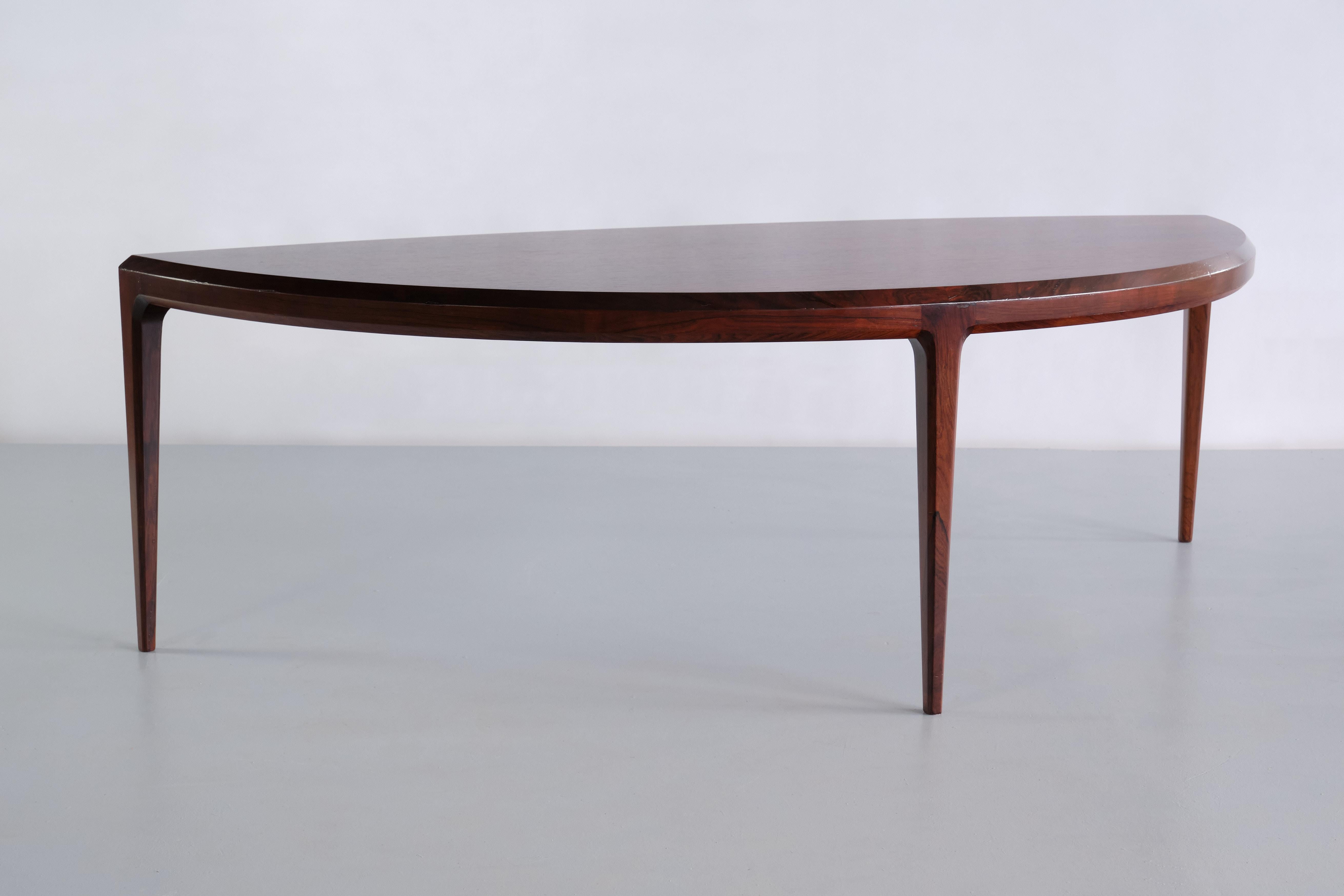 This striking coffee table was designed by Johannes Andersen and manufactured by CFC Silkeborg in Denmark in the early 1960s. The organic, demilune shaped top and the three slim, tapered legs make this a very elegant and modern design. The table is