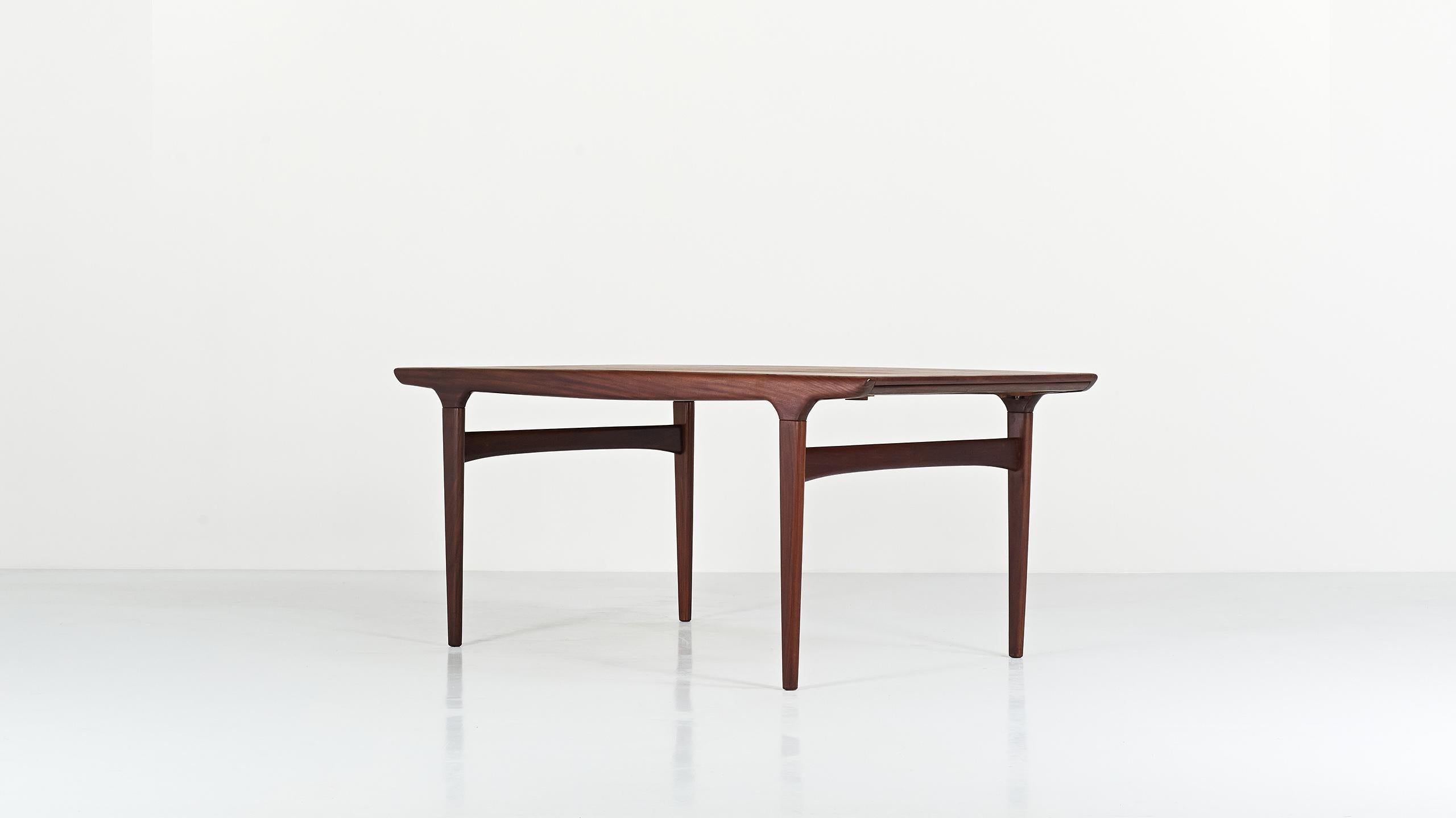 Teak dining table, by designer Johannes Andersen for Uldum Møbelfabrik. Structure in teak and teak veneer. One extension, placed in a compartment under the top, allows the maximum length to be increased to 240cm. Small traces of use, excellent