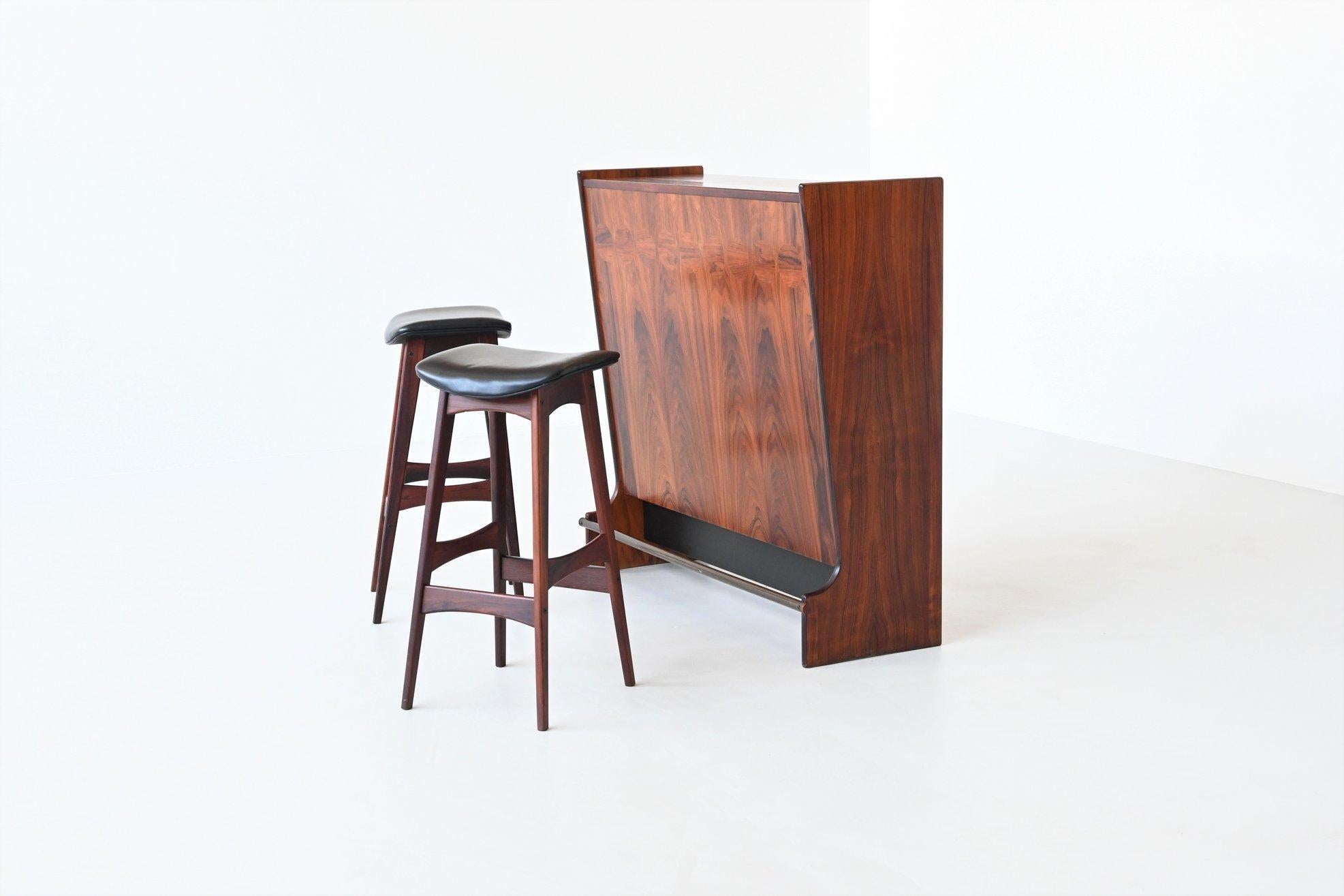 Highly refined freestanding dry bar cabinet with two corresponding bar stools designed by Johannes Andersen for Skaaning & Søn, Denmark 1960.

This decorative yet functional model SK661 liquor bar is executed in rosewood. One side of it features