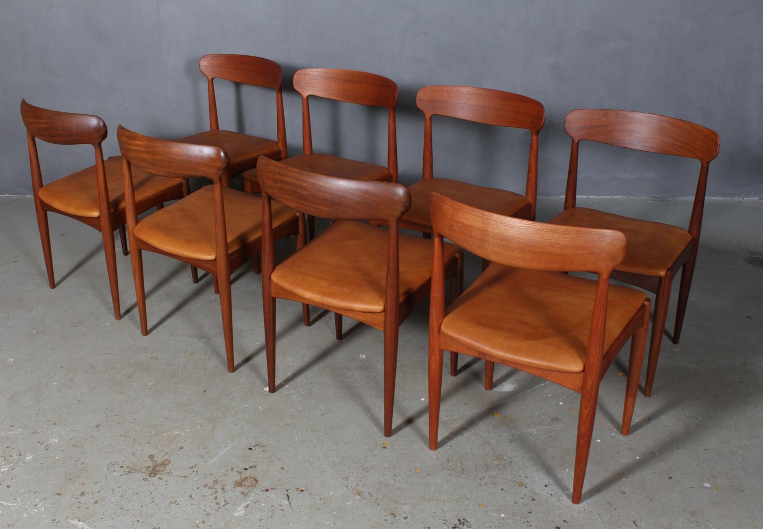 Johannes Andersen eight dining chairs in solid oiled teak.

New upholstered with vintage tan aniline leather.

Made by Uldum Møbelfabrik.