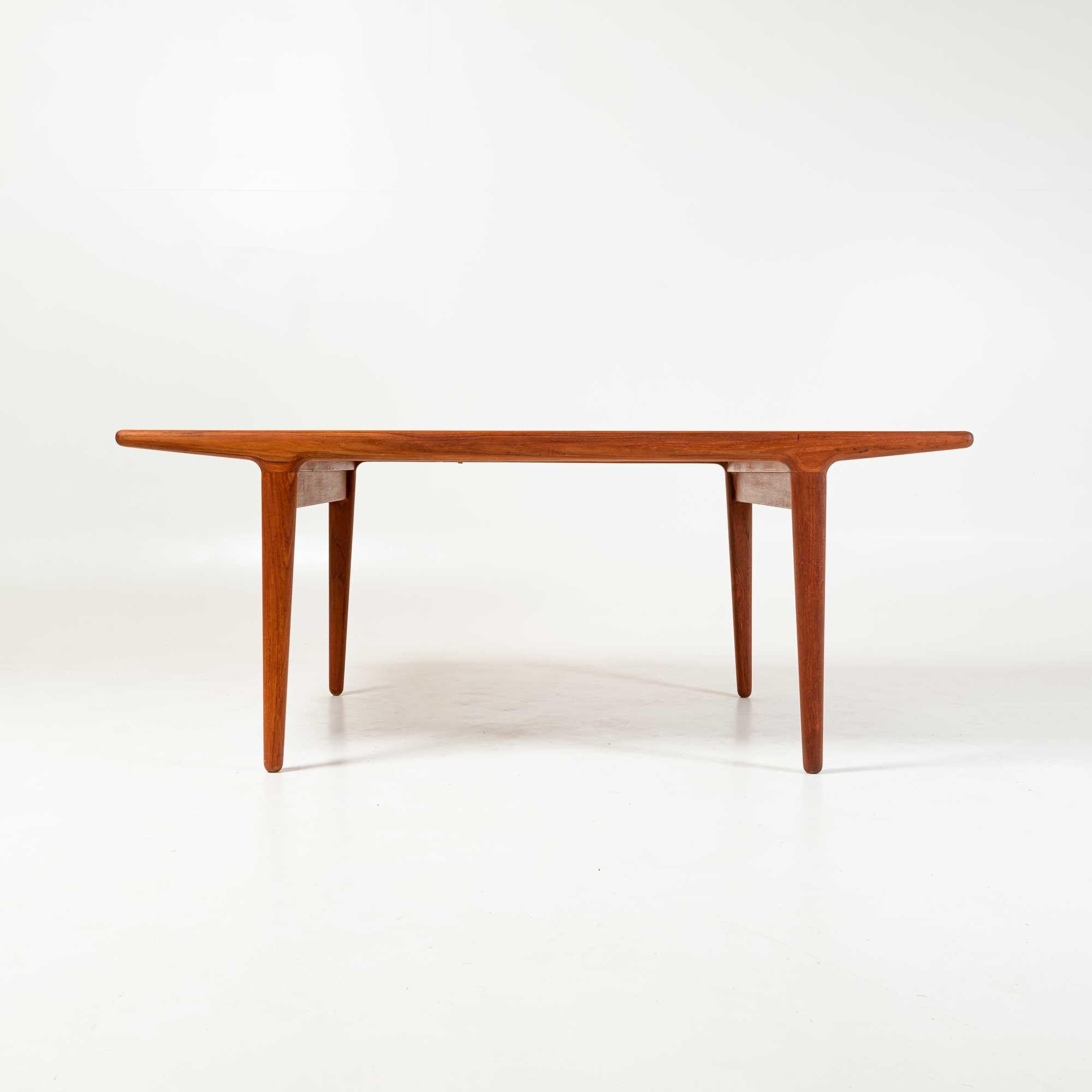 A dining table in teak designed by Johannes Andersen for with clever hidden drawers on both ends concealing two large leaves. The table can accommodate up to 10 seating with extended leaves, or 6 without extended leaves.

Measures: length with