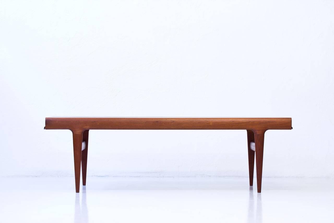 Extendable teak coffee table designed by Johannes Andersen in Denmark during the 1960s. Produced by CFC Silkeborg. Features a drawer with an anthracite melamine tray on one side and an extendable leaf in teak on the other side. High quality in the