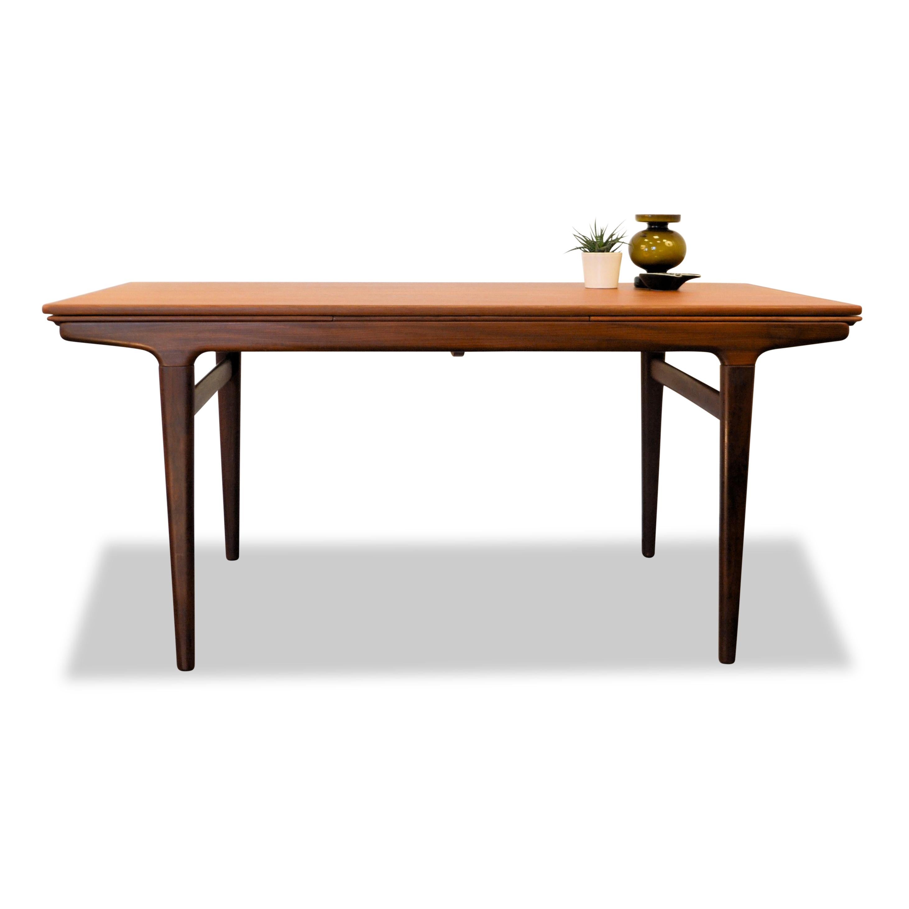 Gorgeous Danish modern teak dining table designed by Johannes Andersen for Uldum Møbelfabrik. Featuring a clean, timeless design and beautiful teak wood. You’ll easily host up to ten (!) dinner guests with the pull-out extension pieces which add up