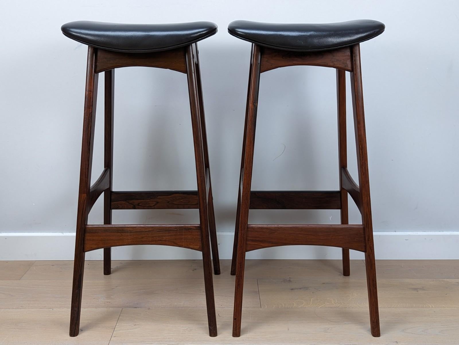 These bar stools are a rare find. They are designed by the renowned Danish designer Johannes Andersen and produced by BRDR Andersen Vejen Møbelfabrik in Denmark. The bar stool is executed in teak and upholstered in black leather.

 The legs are