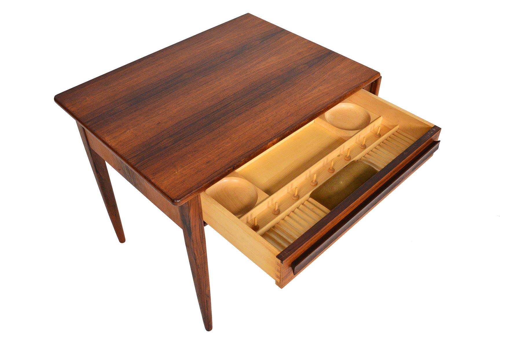 This beautiful Danish modern midcentury sewing box was designed by Johannes Andersen for CFC Silkeborg in the 1960s. A drop leaf can be extended to expand the work surface. A top drawer crafted in oak features multiple compartments for notion
