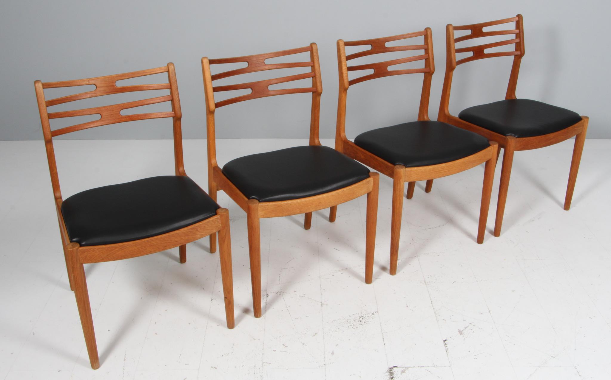 Johannes Andersen four dining chairs in solid oiled oak and teak backrest.

New upholstered with black aniline leather.

Made by Vamo Møbelfabrik.
