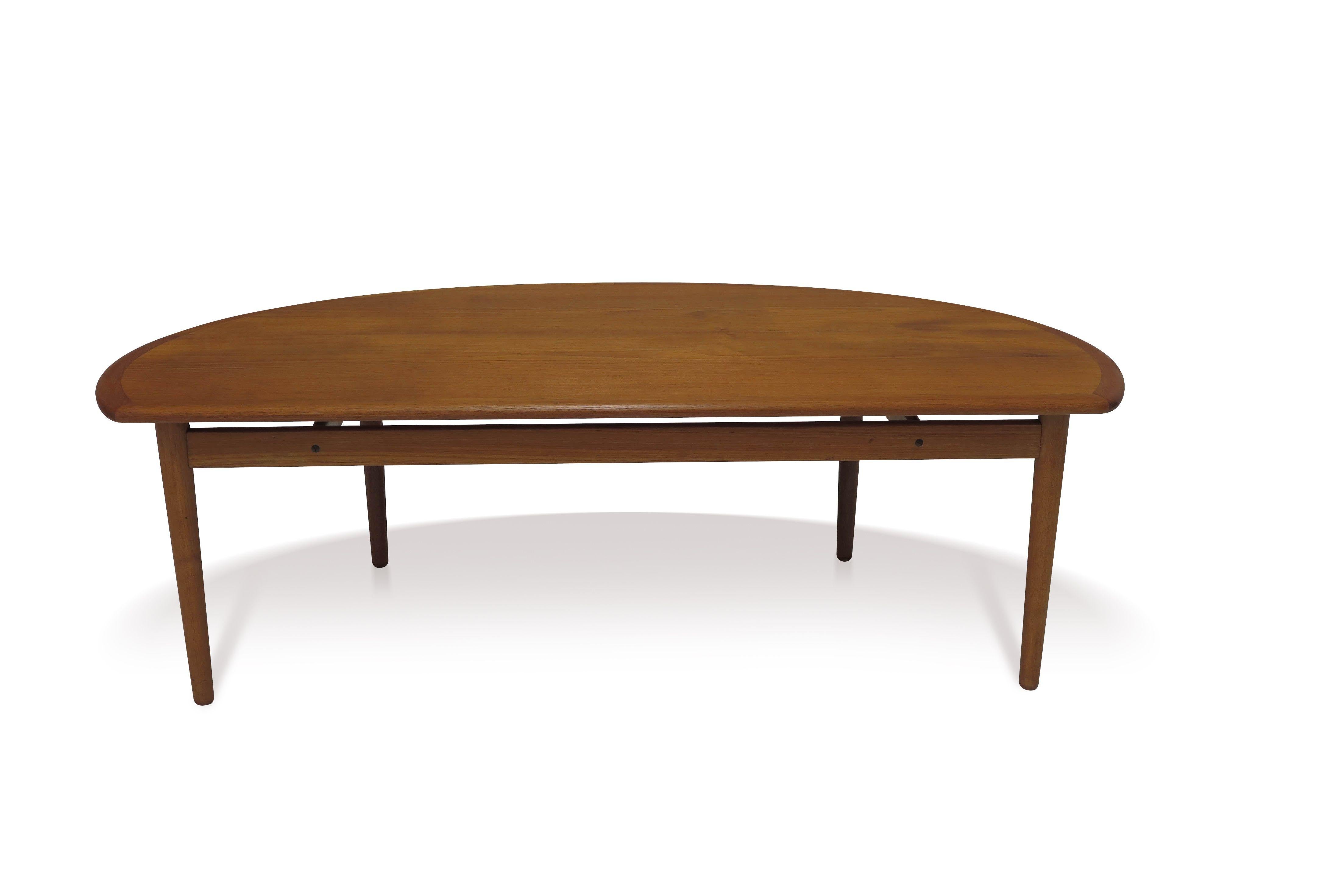 Mid-century Danish teak coffee table designed by Johannes Andersen crafted of old-growth teak with half round form raised on solid teak tapered legs with cross stretchers.