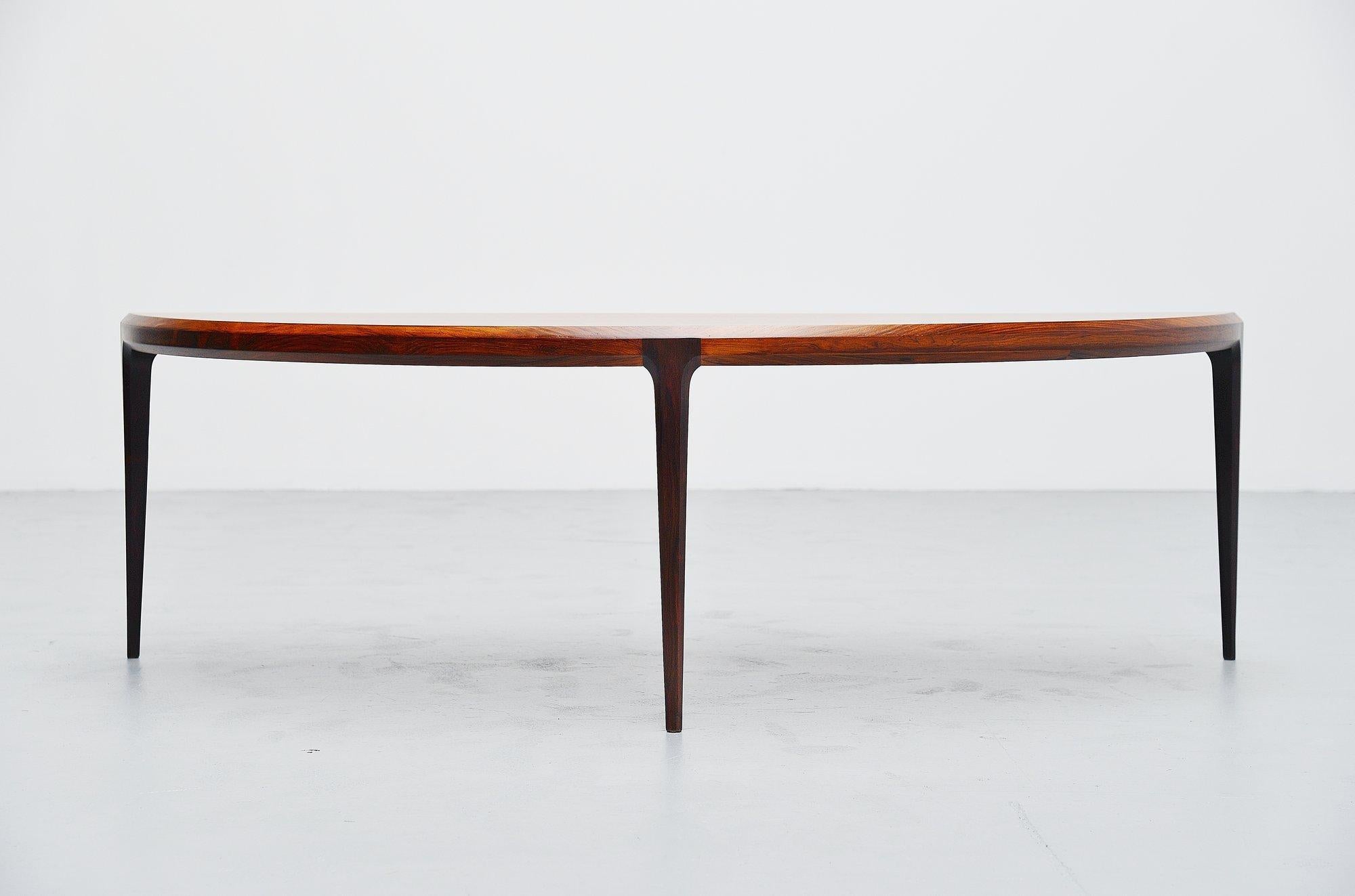 Nice moon shaped rosewood coffee table designed by Johannes Andersen and manufactured by CFC Silkeborg, Denmark 1960. This very nicely finished coffee table with very nice and deep rosewood grain to the wood can finish your interior into perfection.